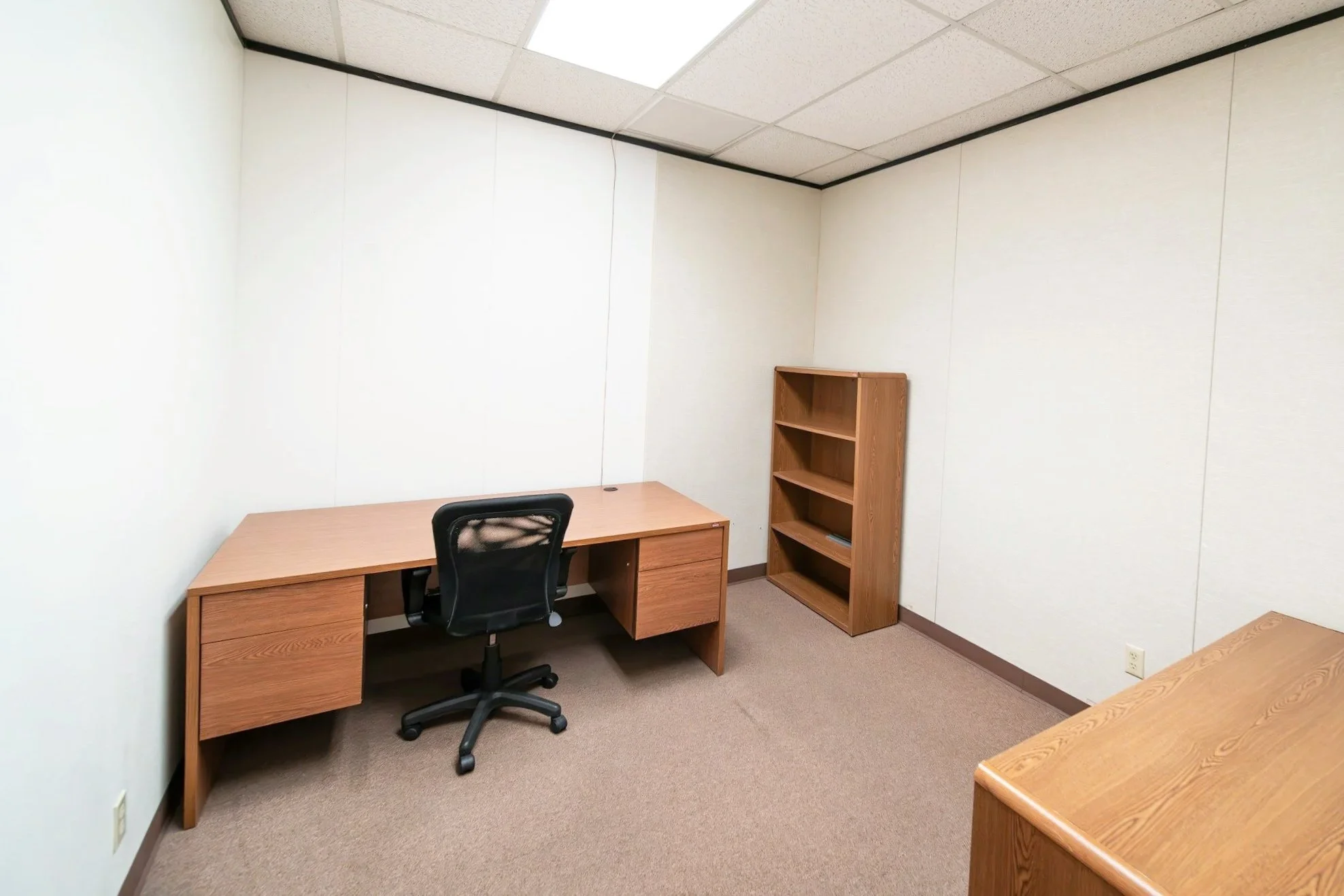 Emptied office with furniture stacked for licensed removal.