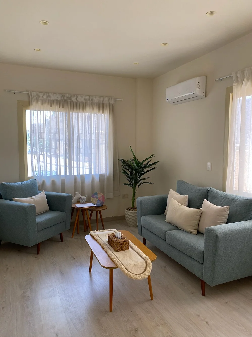 The seating corner at Lotus Therapy, two blue sofas in soft daylight