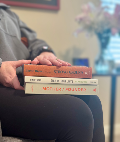 Root & Rise Consulting Owner in her office reading books