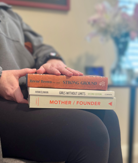 Root & Rise Consulting Owner in her office reading books