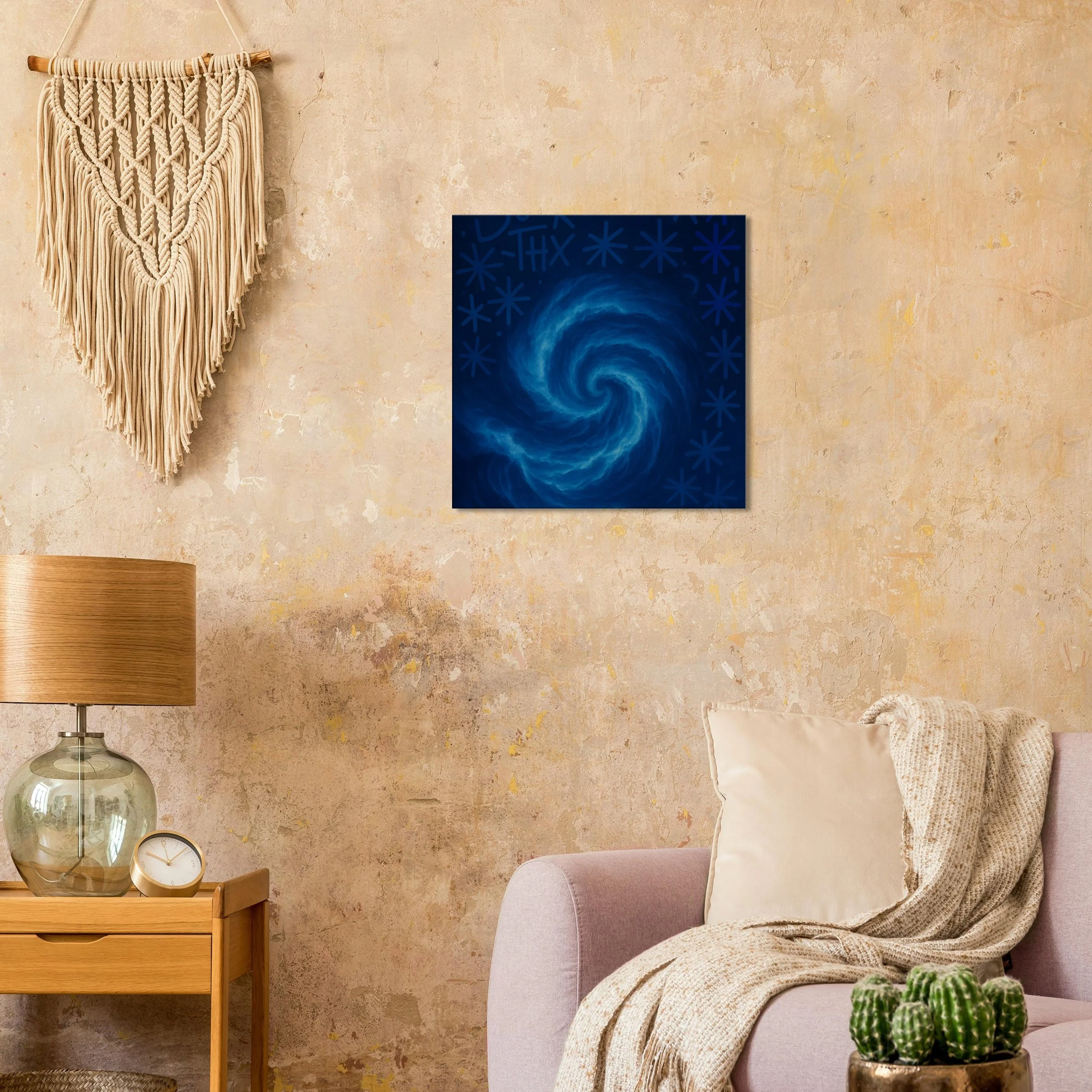 A cozy living room corner with a textured beige wall, a macrame wall hanging, and a blue abstract swirling painting. There is a side table with a lamp and a clock, an armchair with a cream pillow and knitted throw, and a cactus in a pot.
