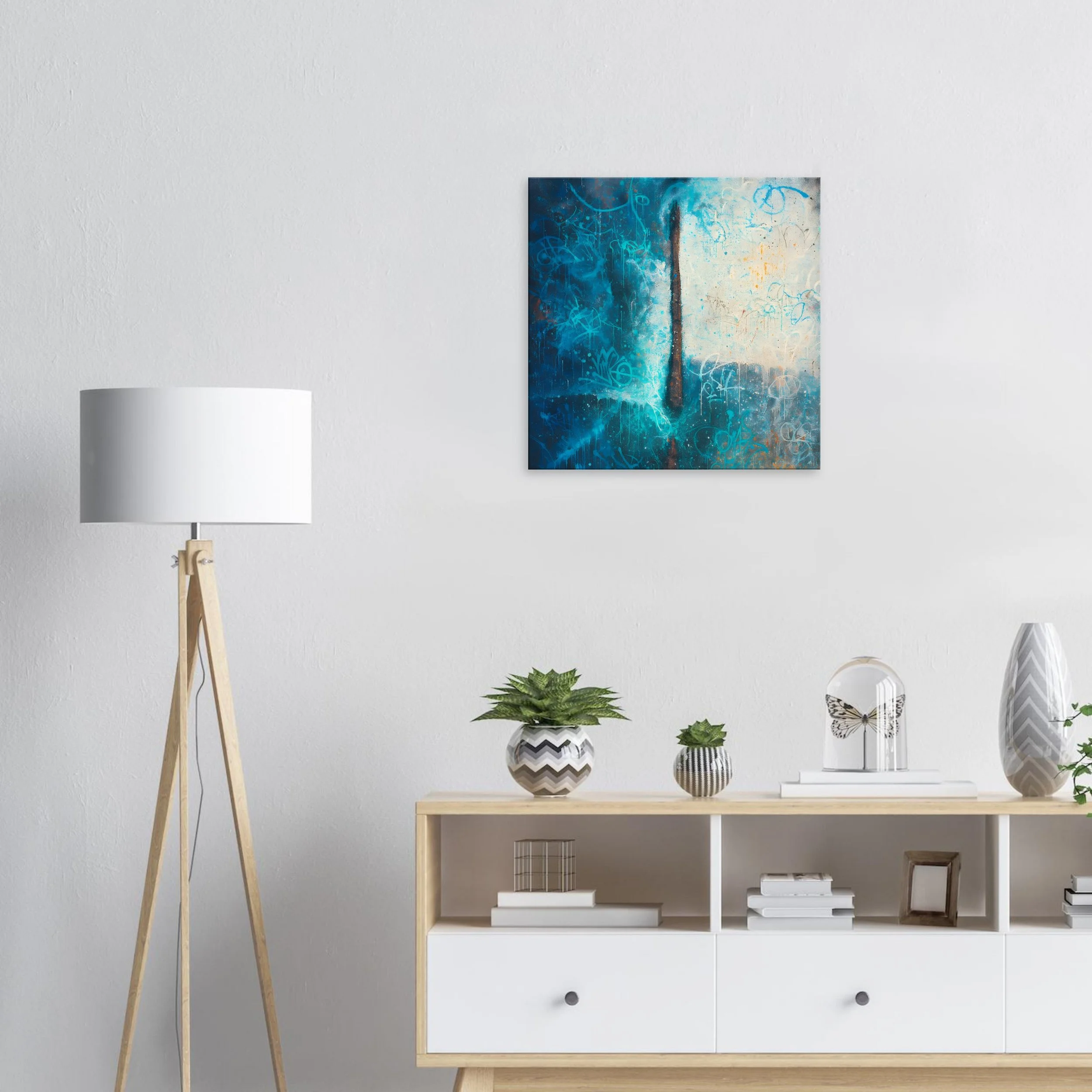 Modern living room with a white wall, a wooden and white media console, potted plants, a small sculpture, and abstract artwork on the wall.