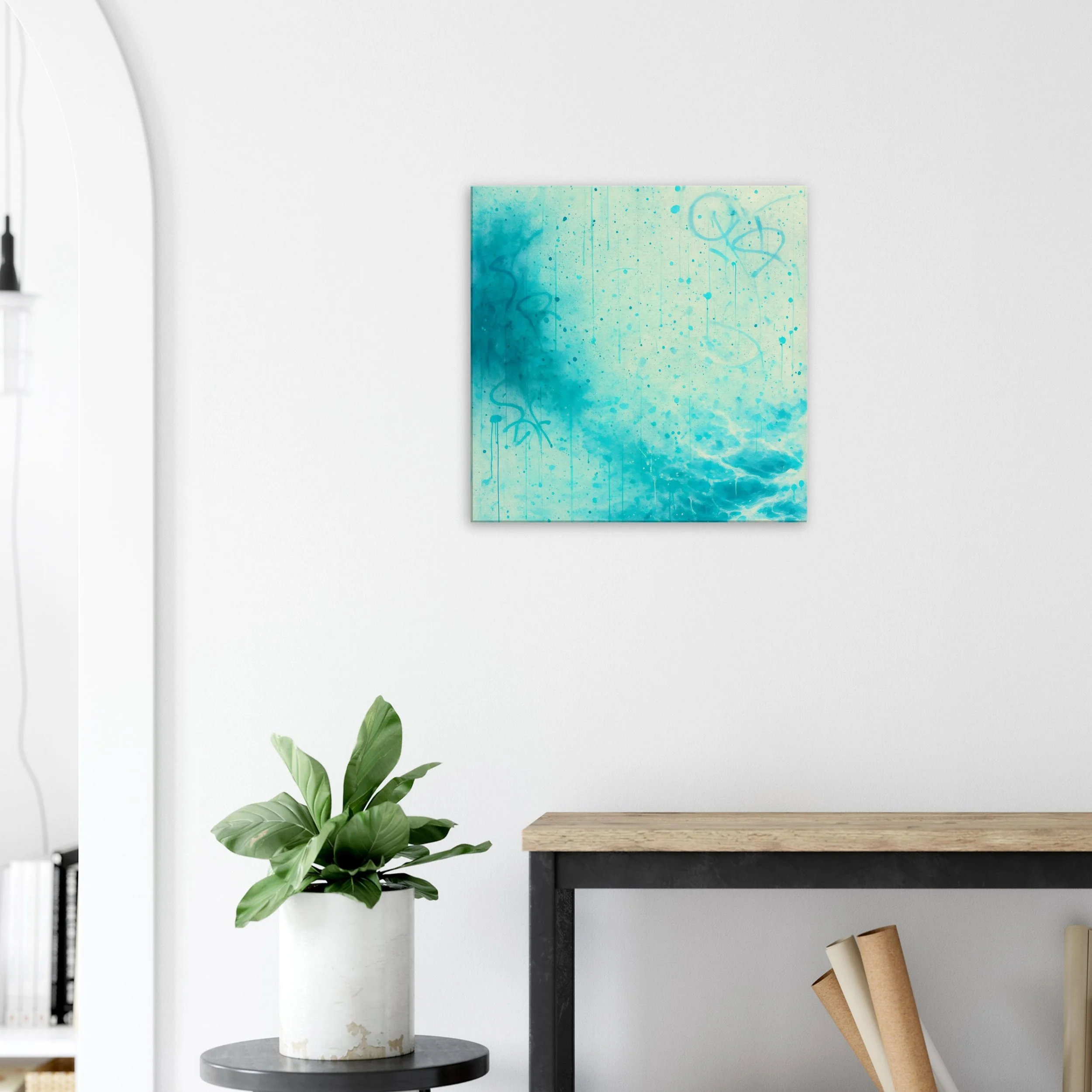 Modern living room with a white wall, a colorful abstract blue and green painting, a potted plant on a round table, and a wooden table with books.