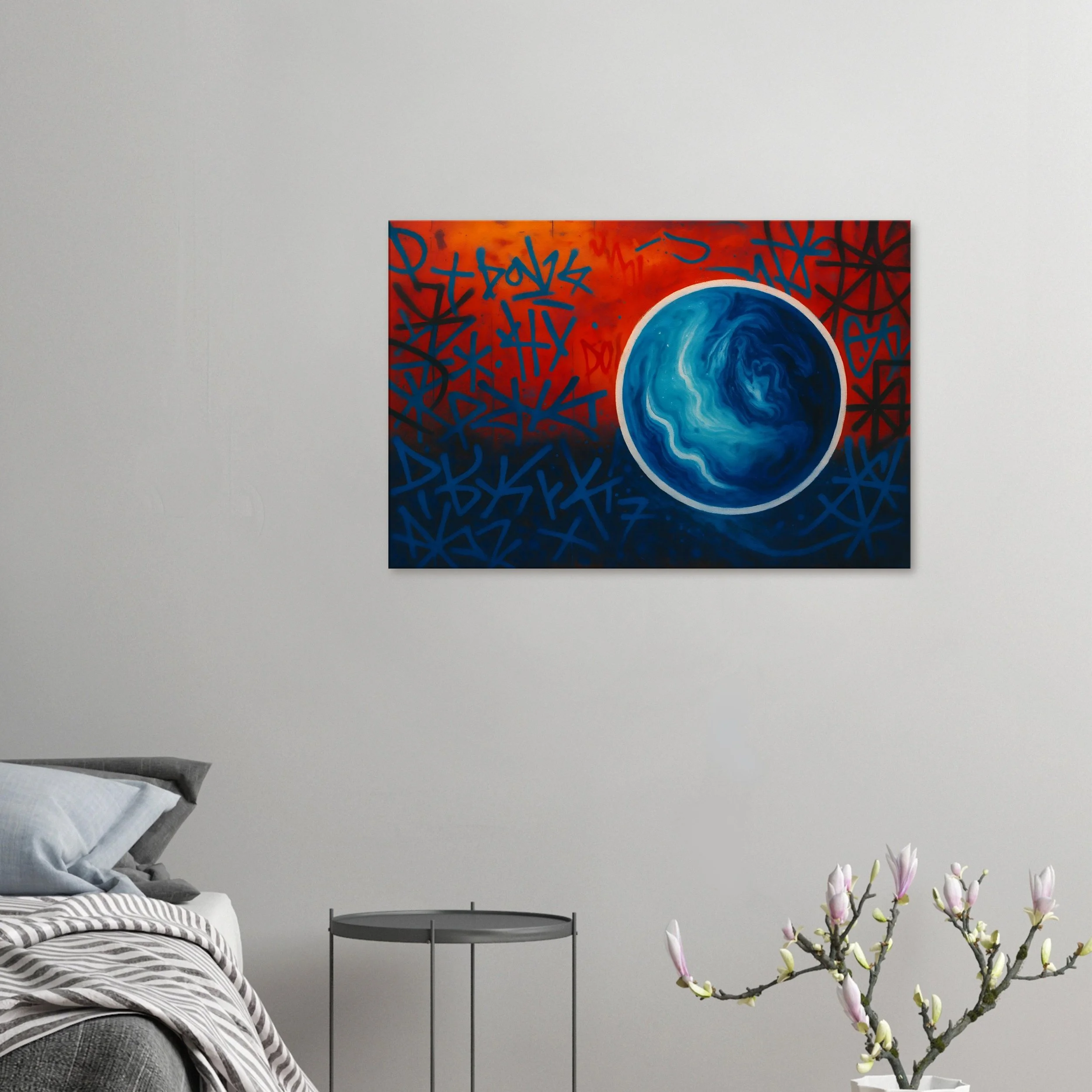 A modern living room with a white wall and a colorful abstract painting featuring a blue and white globe and red and blue graffiti-style background, a bed with striped bedding, a small side table, and a magnolia branch with pink buds in a white vase.