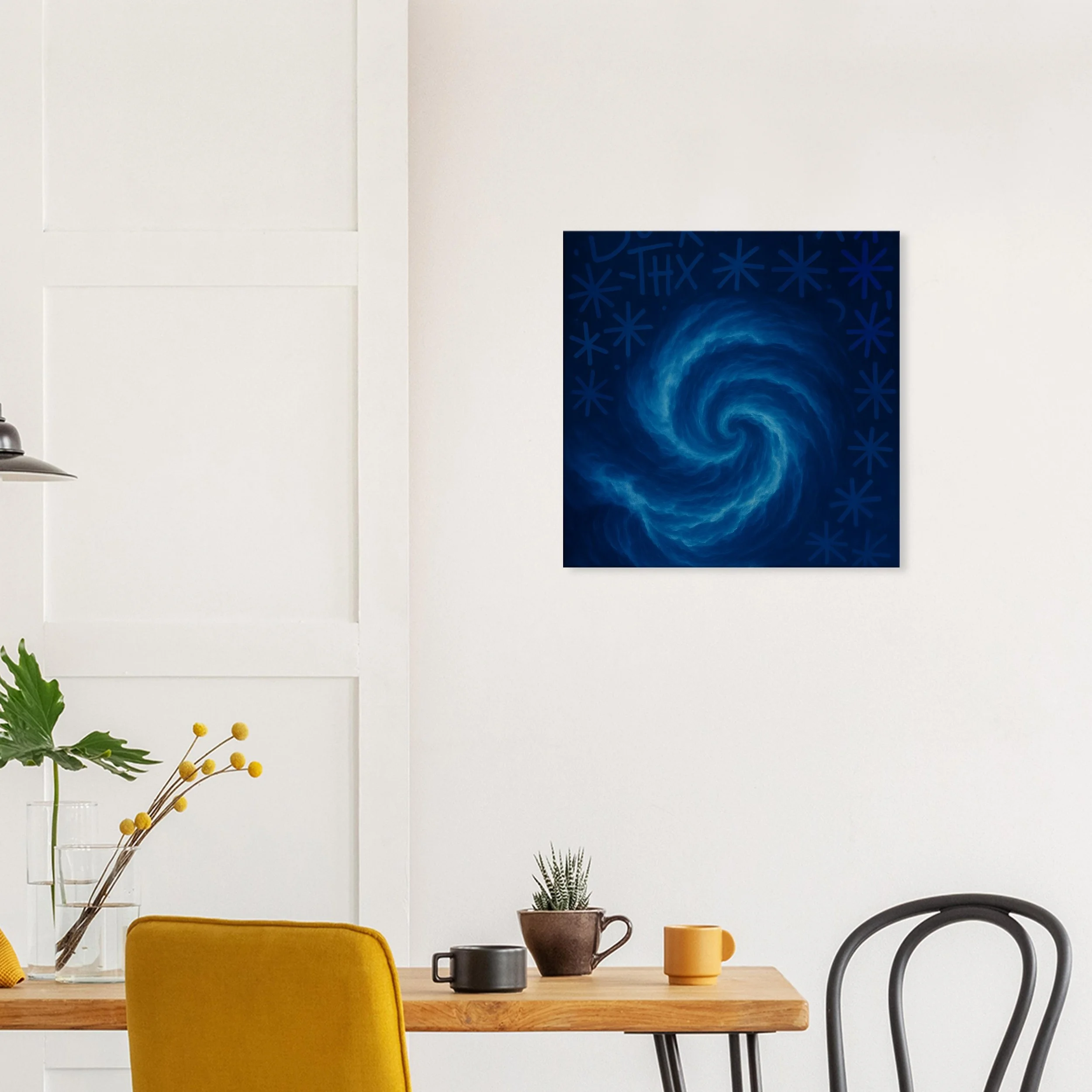 A modern dining room with a white wall, a wooden table, and a yellow chair. On the wall, there is a dark blue abstract painting resembling a swirling galaxy with blue stars.