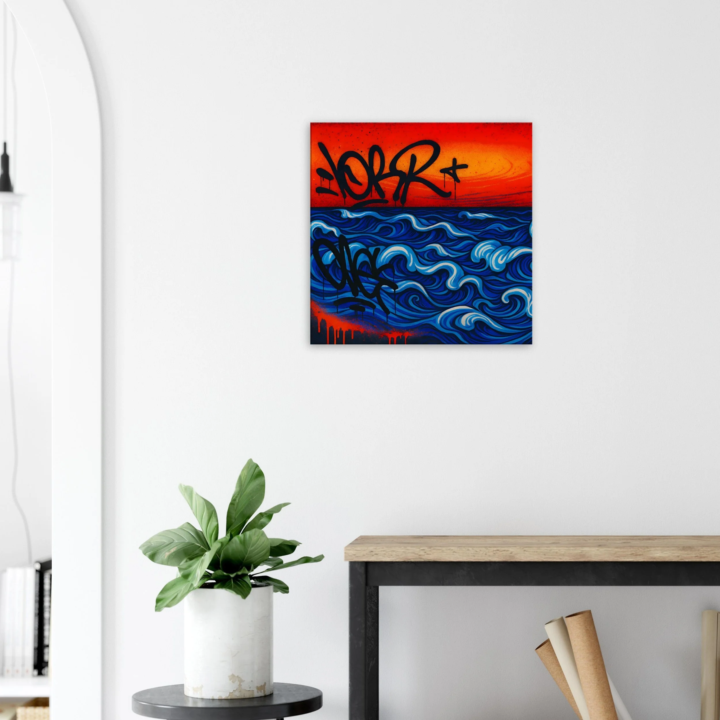 A colorful abstract painting of blue ocean waves with a red and orange sunset sky, supported by black graffiti-style tags, hung on a white wall in a modern room.