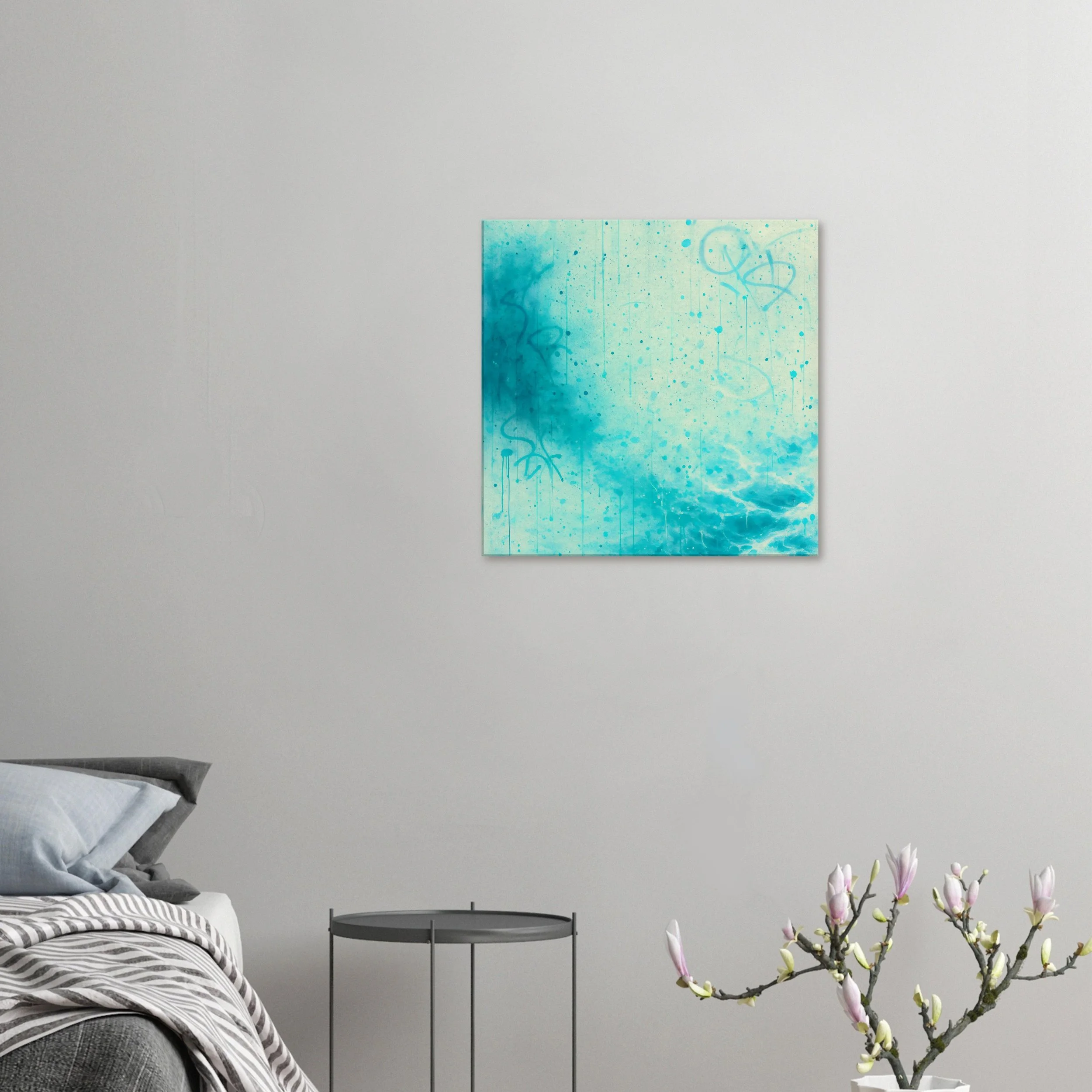 Interior of a modern bedroom with a gray bed, a small black side table, a white wall with a blue abstract painting, and pink magnolia flowers.