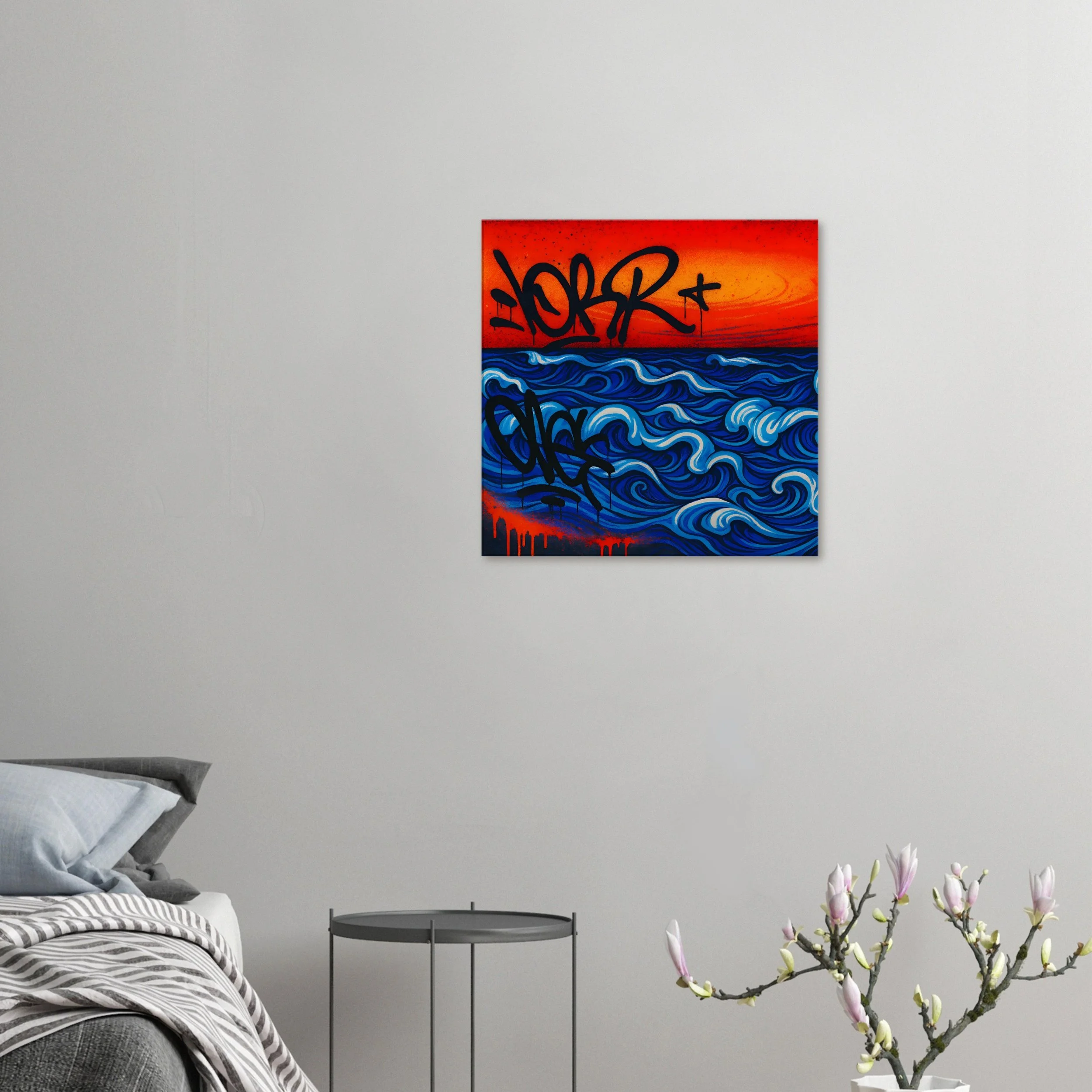 A modern bedroom with a bed, a small round side table, and a painting of a vibrant sunset over the ocean with graffiti-style black lettering on the wall.