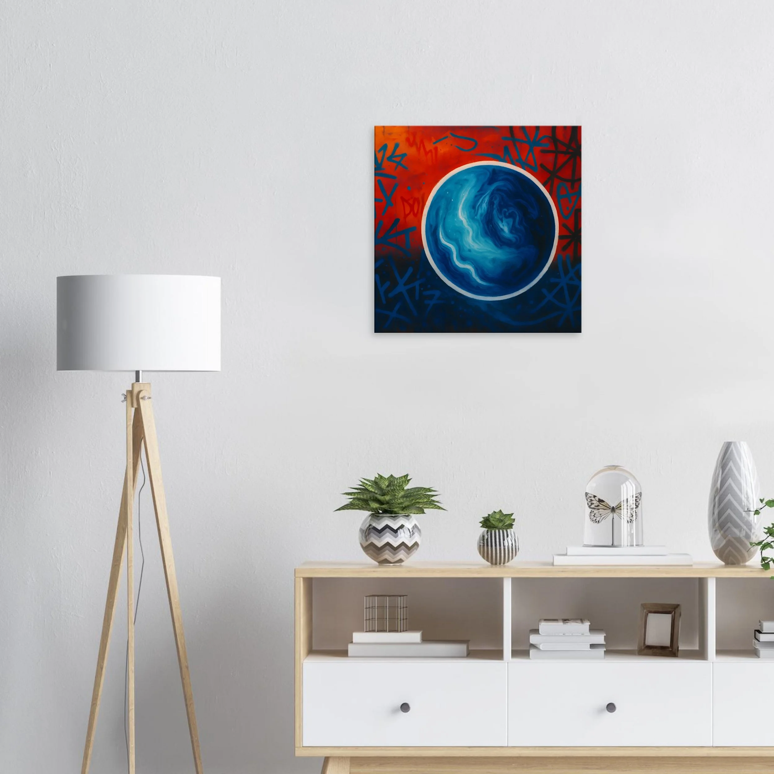 Abstract painting of a blue and white swirling circle on a red and blue background with graffiti-style markings, hung on a plain white wall.