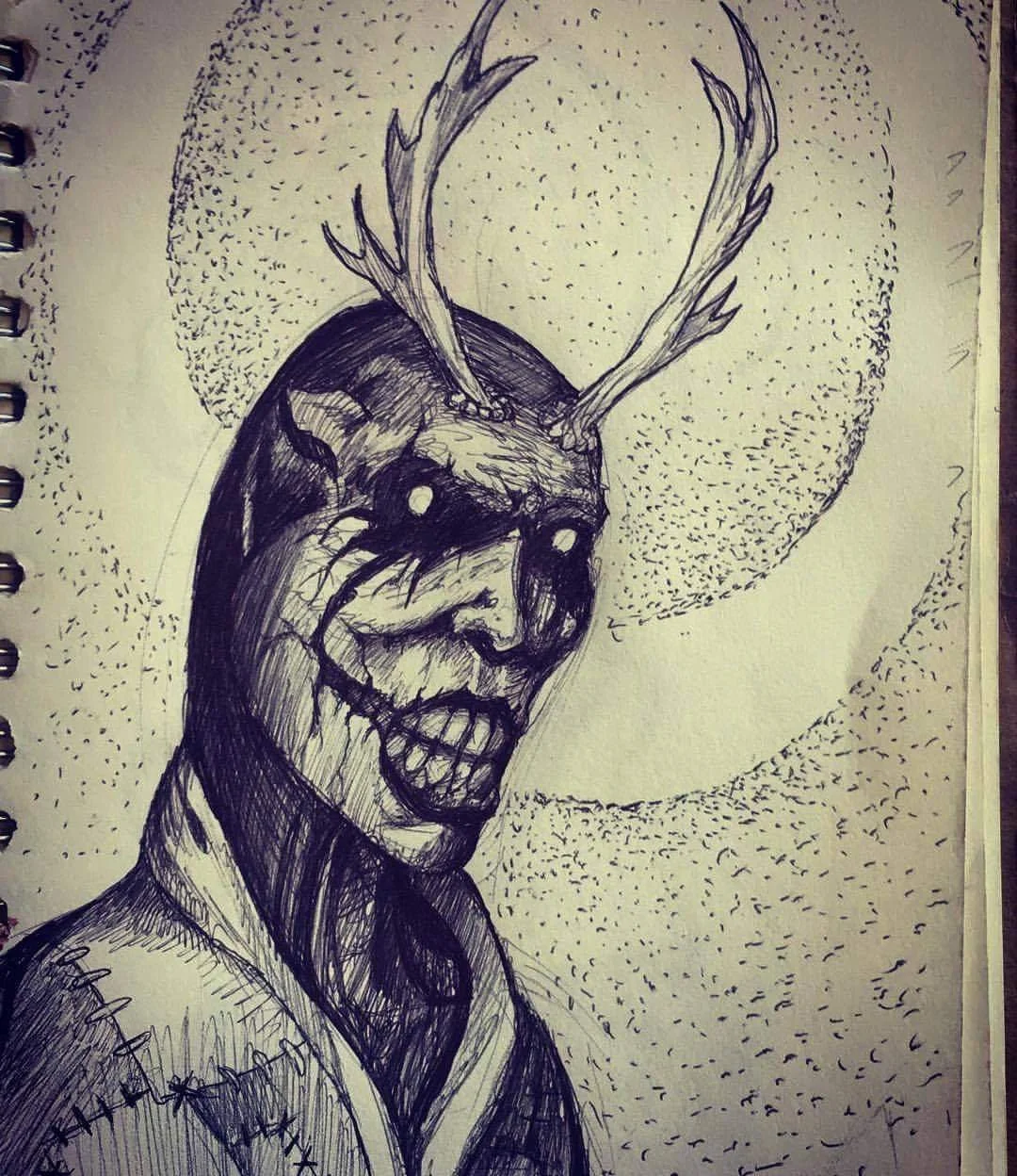 Black ink sketch of a woman's face merged with a deer skull with antlers, surrounded by a dotted circular pattern.