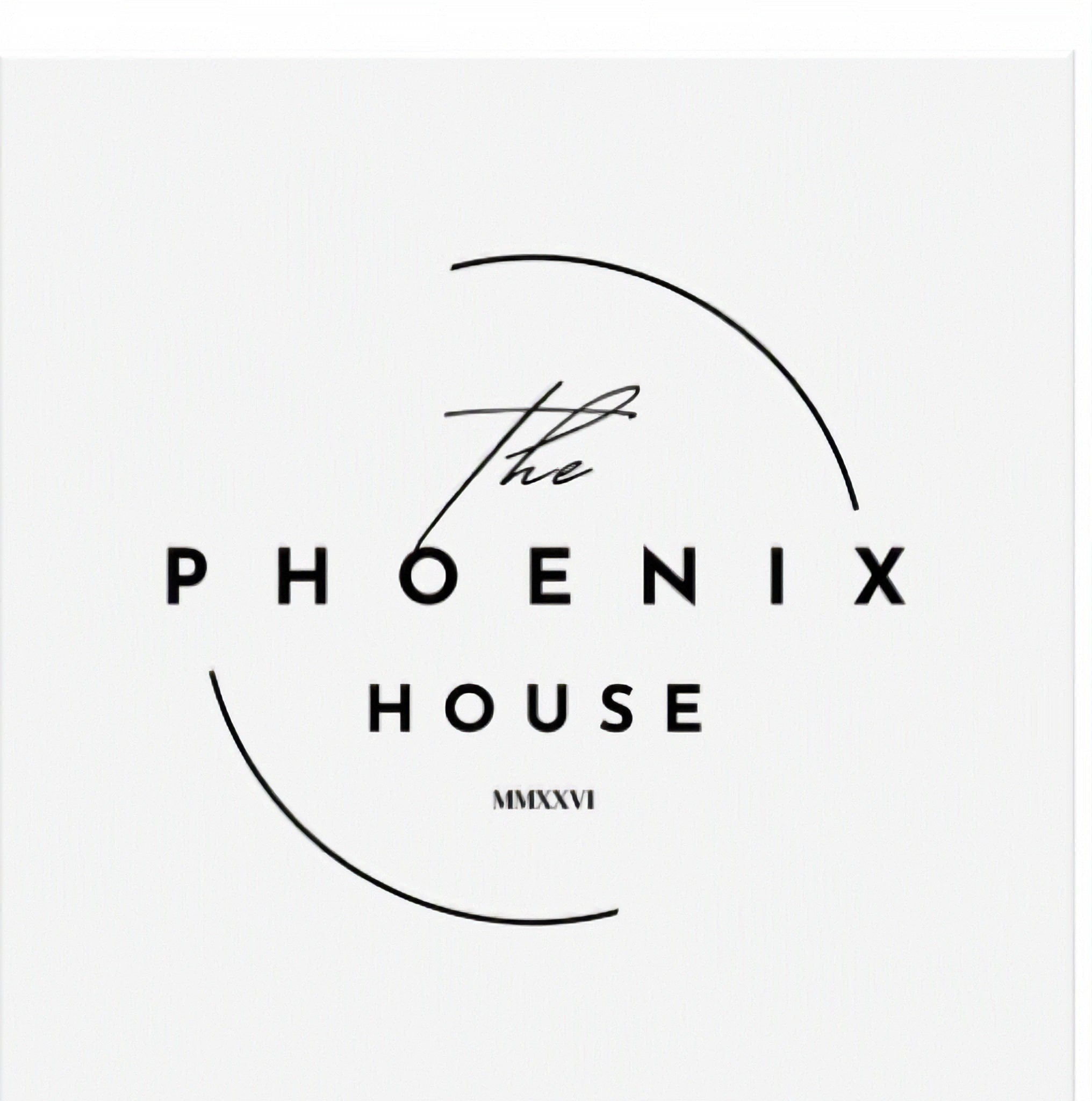 Close-up of a white surface with black text that reads 'The Phoenix House' and some Roman numerals, along with a black curved line.