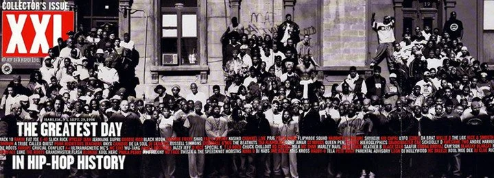 A large group of people sitting and standing on the steps and ledge of a building, with a newspaper cover overlay labeled 'XXL The Greatest Day in Hip-Hop History'.