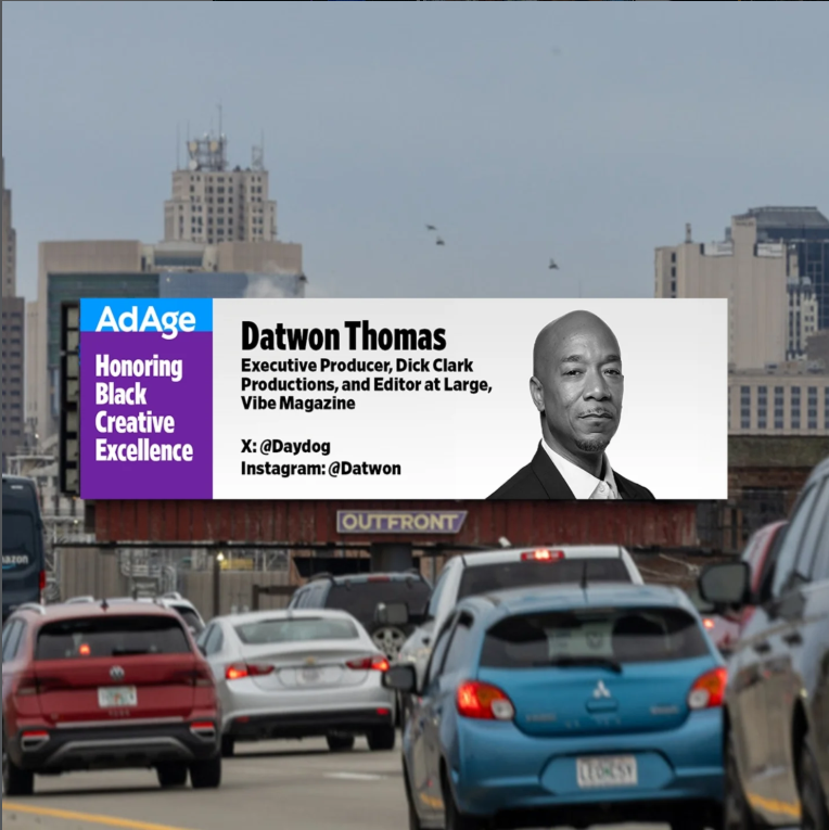 City street with cars and a billboard honoring Datwon Thomas, who is an executive producer at Dick Clark Productions and editor at Large, Vibe Magazine, with social media handles @Datvog and @Datwon.