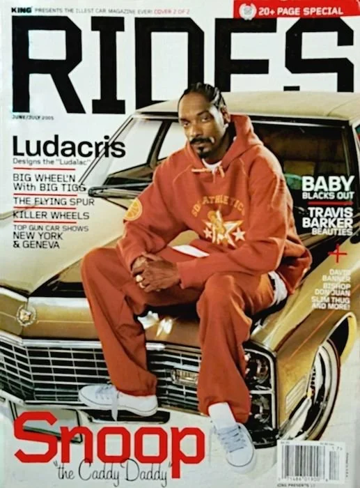 Magazine cover featuring Snoop Dogg sitting on a gold car, wearing a red hoodie and sweatpants, with a black and white background and various headlines about cars and celebrities.