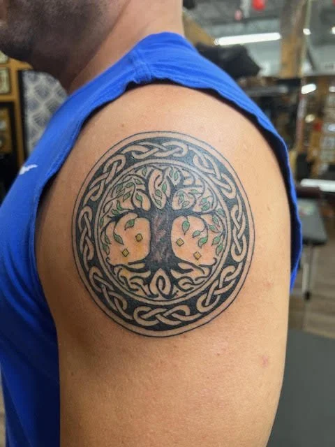 A Celtic-inspired Tree of Life design featuring interwoven knotwork and soft green and gold tones. The balanced symmetry and classic detailing celebrate strength, growth, and connection.