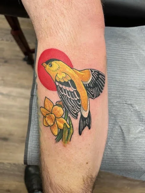 A bright goldfinch in flight paired with a red sun and yellow daffodils. The saturated colors and bold outlines give this design a lively neo-traditional feel.