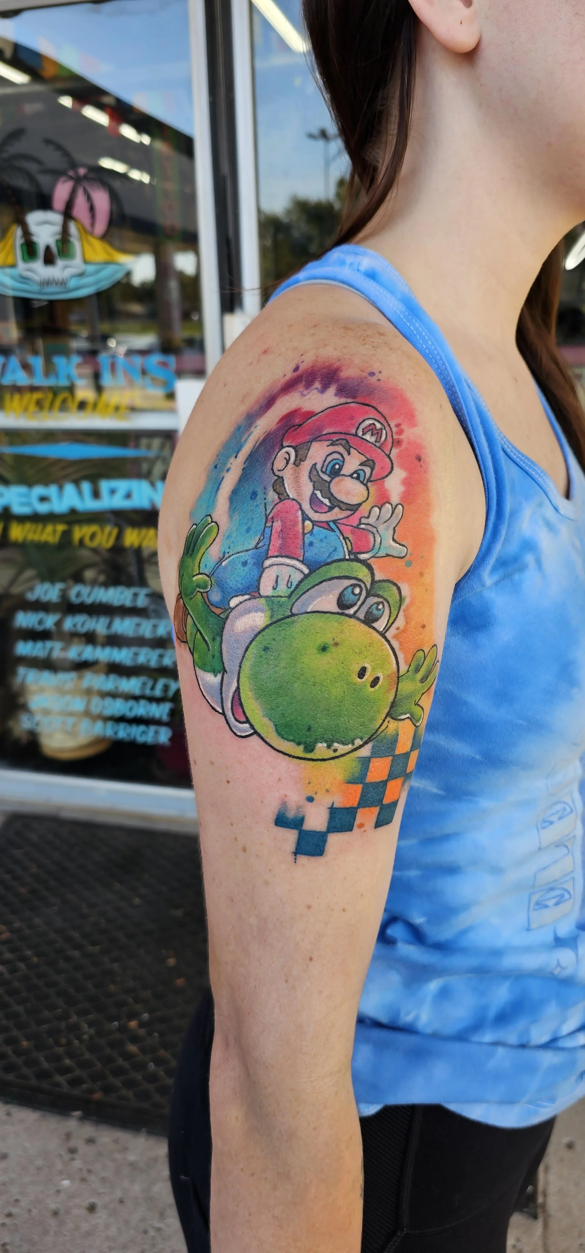 Mario riding Yoshi is rendered in bright, saturated color with a flowing watercolor backdrop that blends blues, reds, and oranges. The energetic brushstroke effect and checkered racing pattern give the piece playful movement and video-game nostalgia.