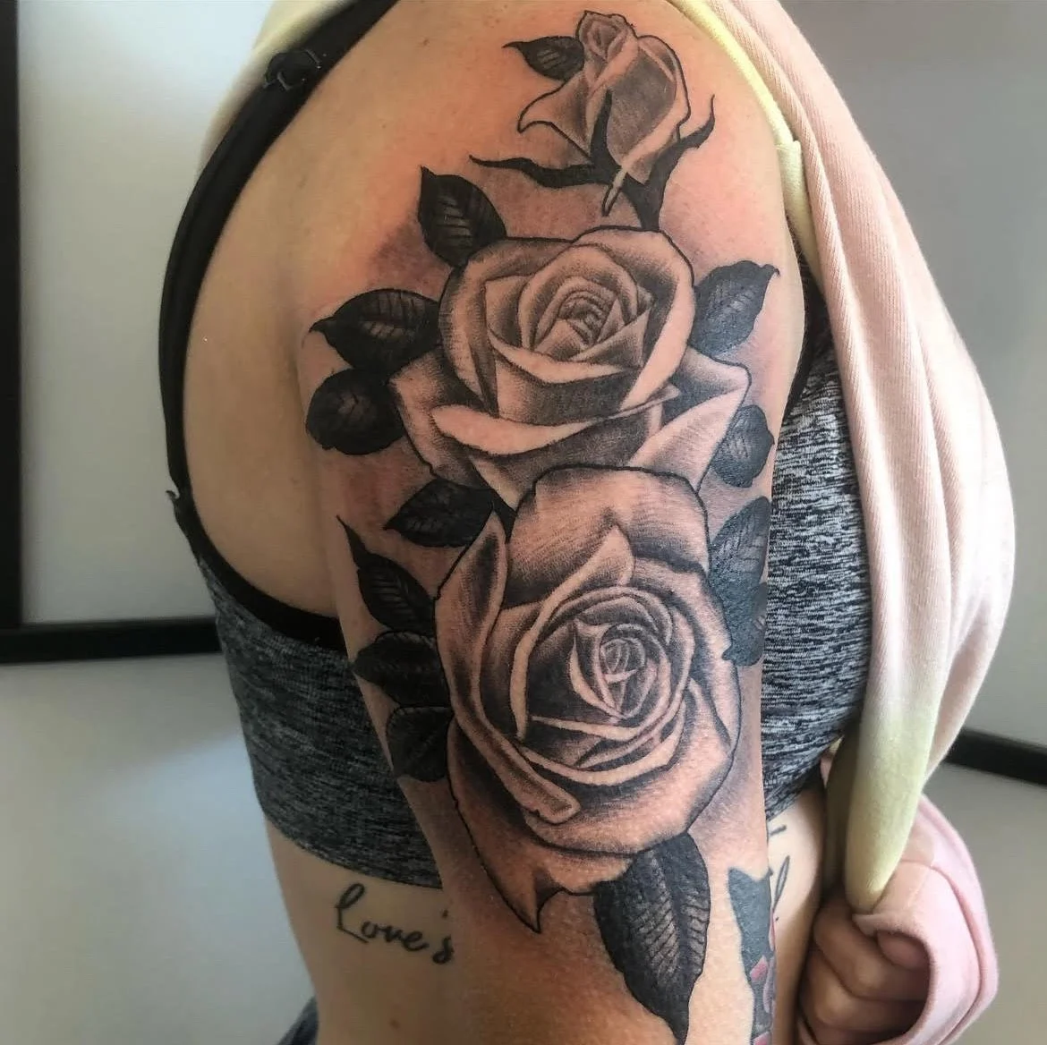 A detailed black and grey piece featuring cascading roses with realistic depth and shading. The soft gradient work adds an elegant and timeless look to this classic floral tattoo.