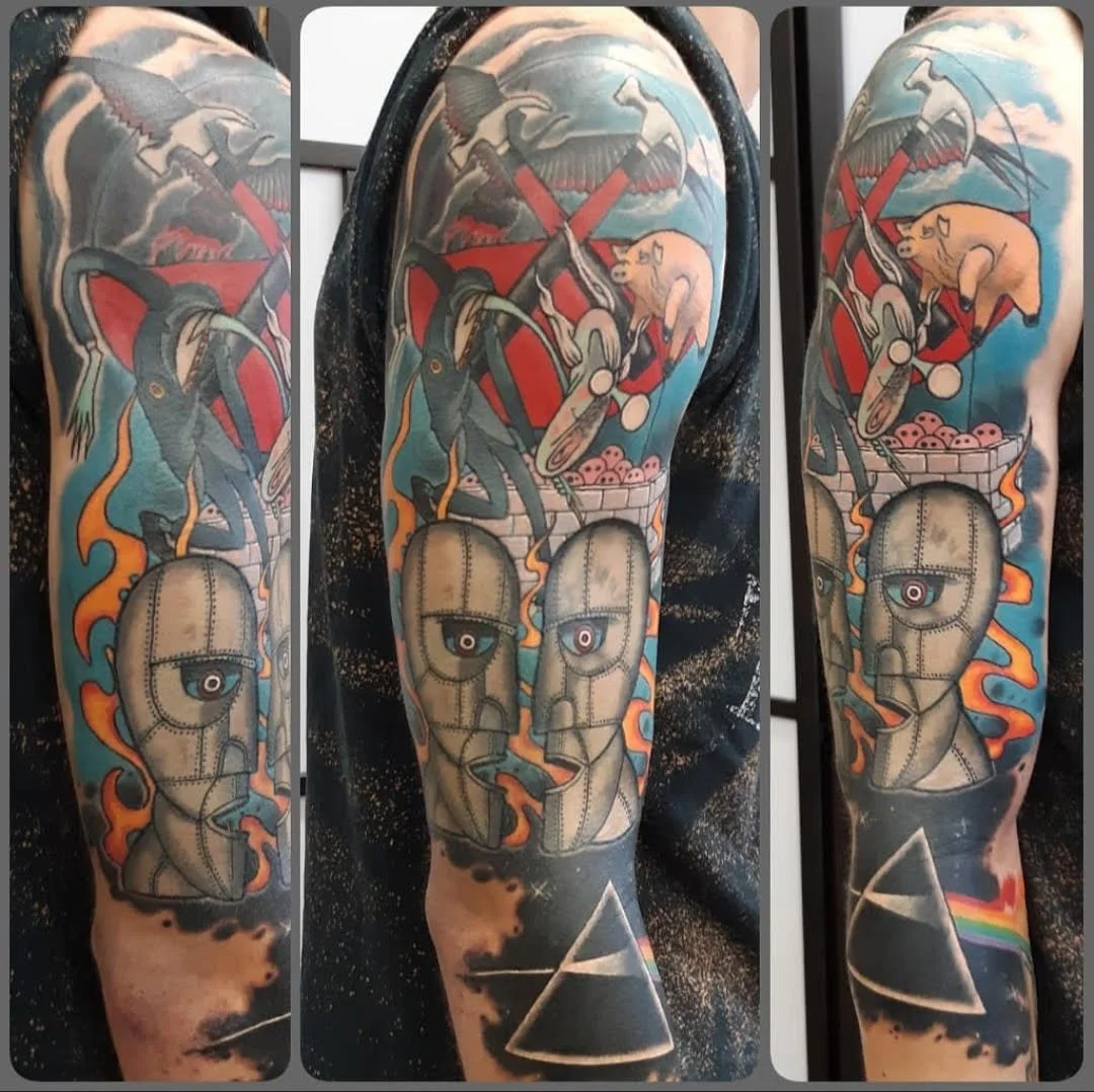 This tattoo blends iconic imagery inspired by surreal album artwork, featuring hammer-march motifs, stylized figures, and abstract shapes. The piece uses strong color blocking and illustrative shading to create a nostalgic, expressive homage with a d
