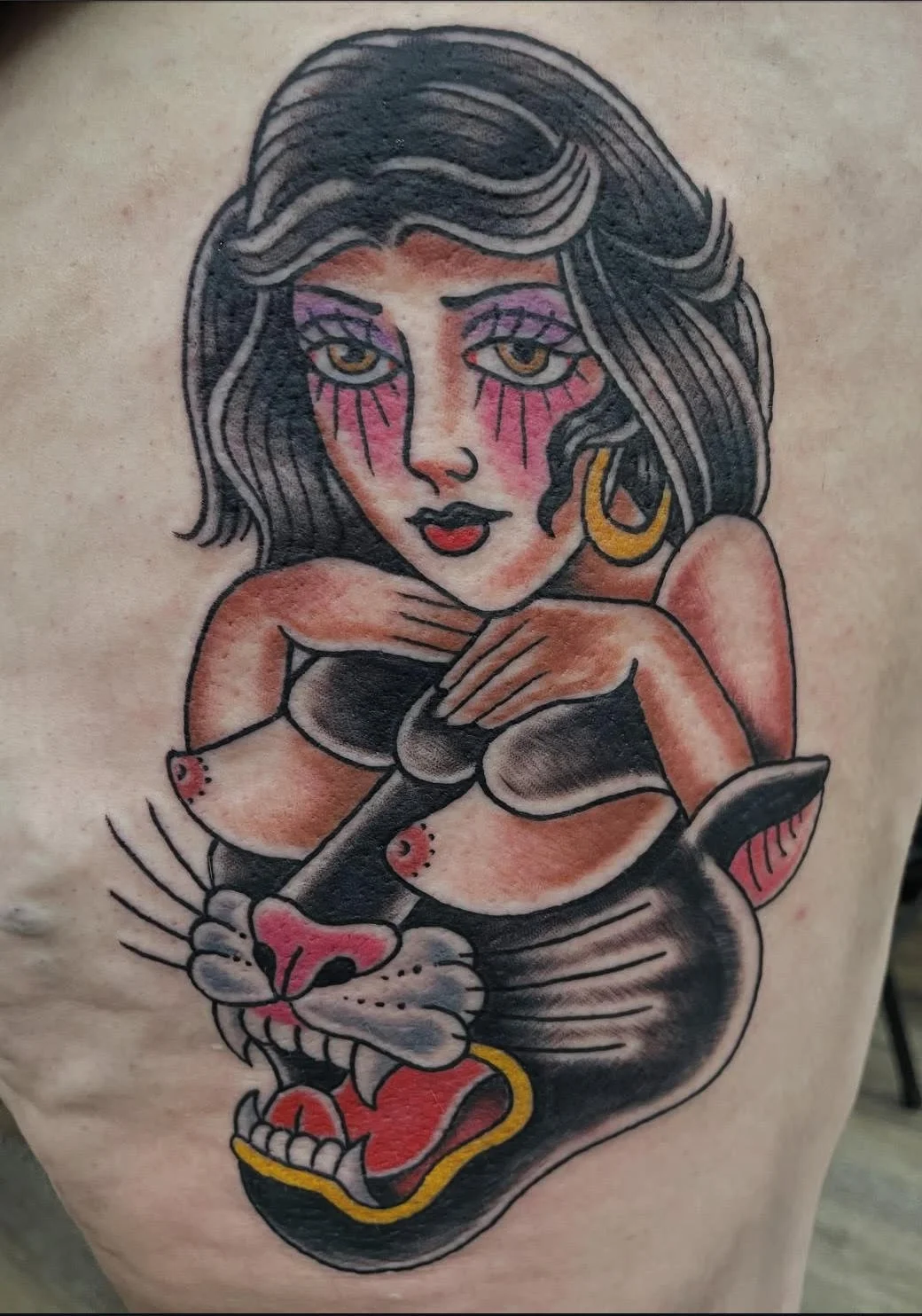 A traditional-style panther morphing into a woman with dramatic eyes and vintage makeup. The design blends classic pin-up and animal motifs for a unique, old-school statement piece.