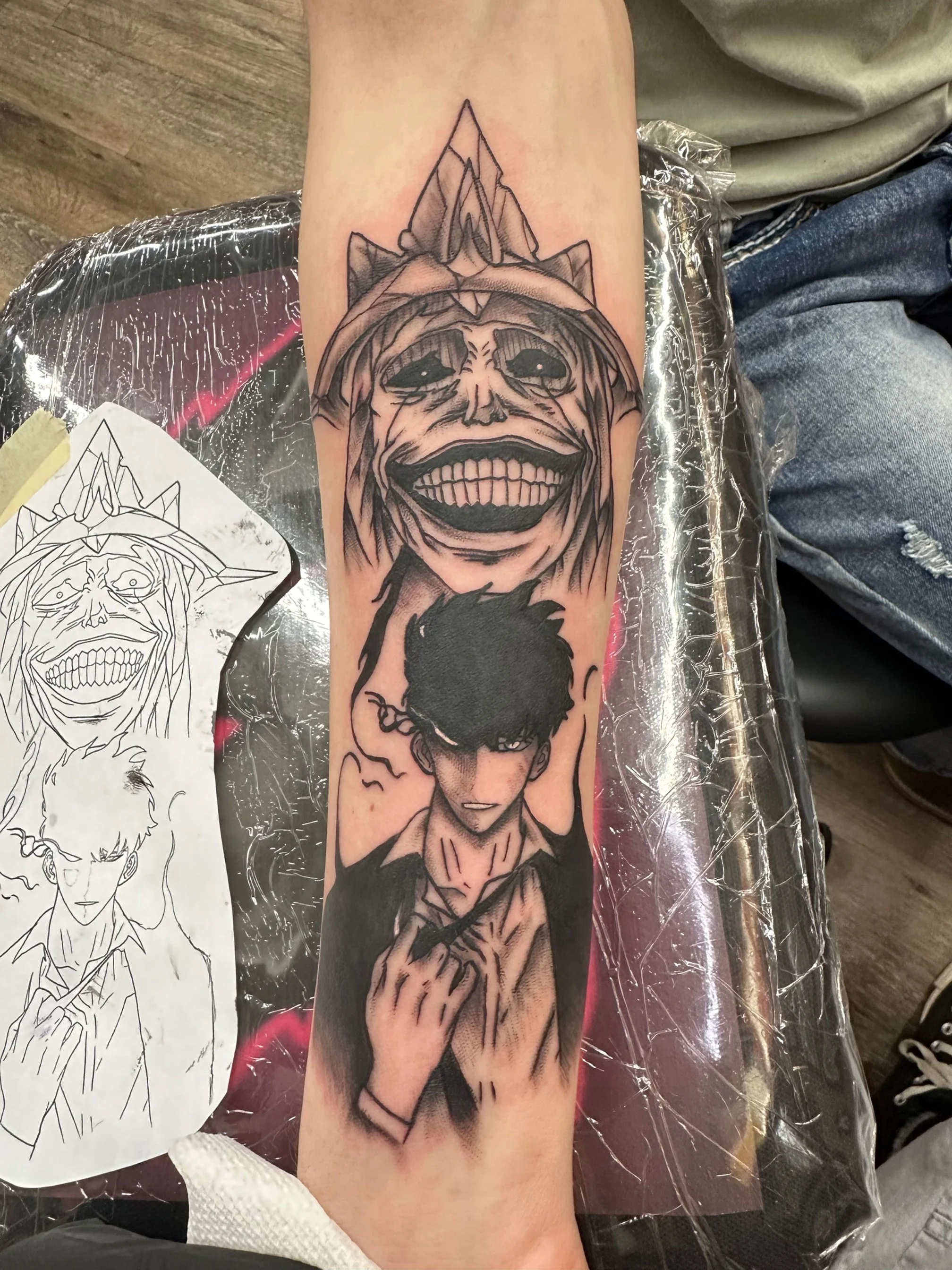 A striking black and grey tattoo inspired by Attack on Titan, featuring Eren Yeager and his Titan form. The intense contrast and stylized shading highlight emotion and power from the anime’s core themes.