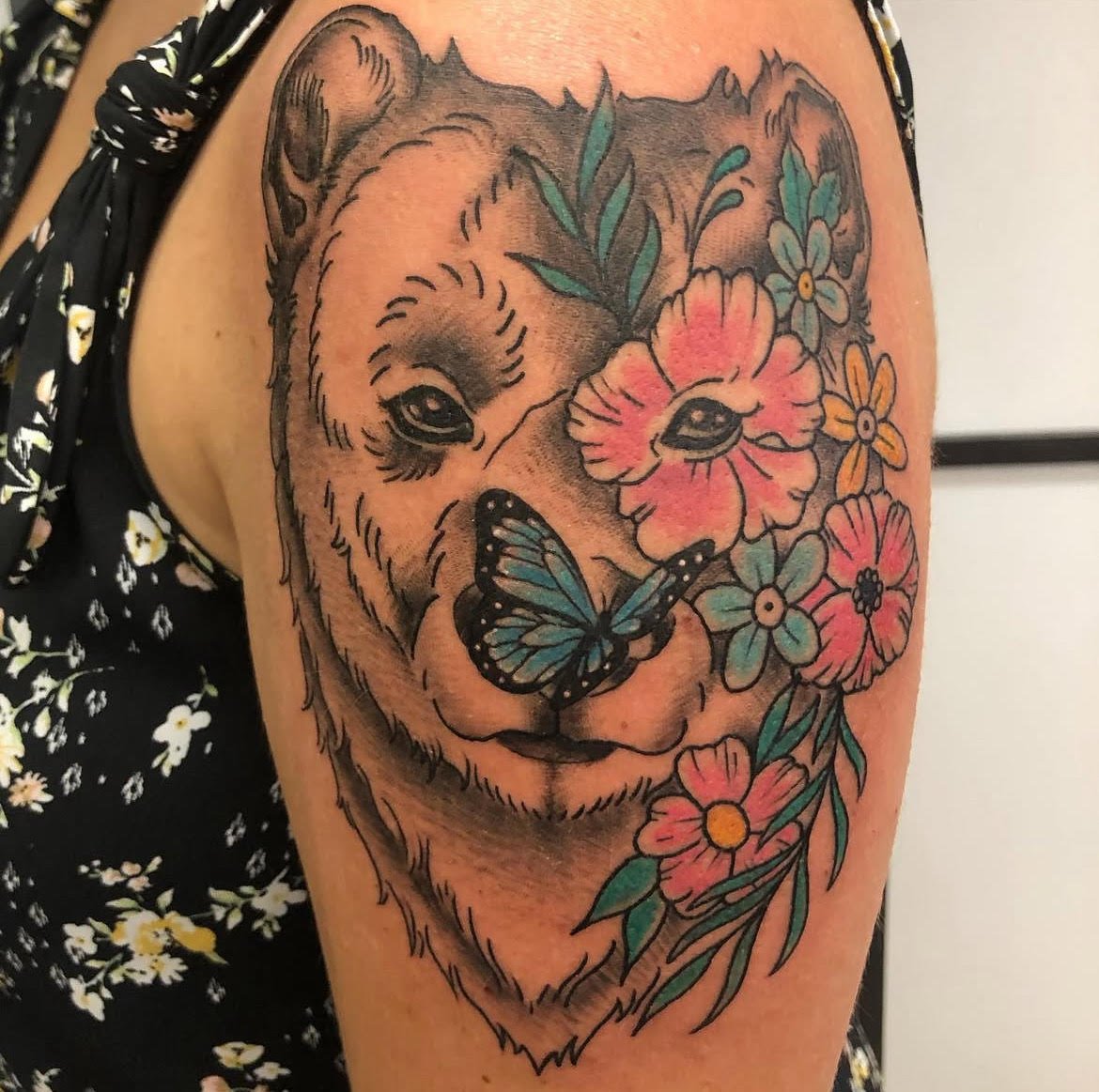 A gentle bear portrait surrounded by bright flowers and a blue butterfly. The soft shading and pastel colors combine nature and calm symbolism beautifully.