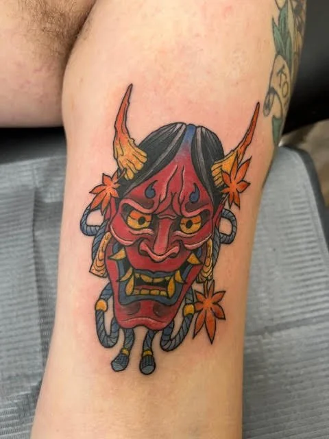 A bold, traditional Japanese Hannya mask accented with vivid reds, golds, and oranges. The crisp linework and color balance convey both intensity and classic Japanese artistry.