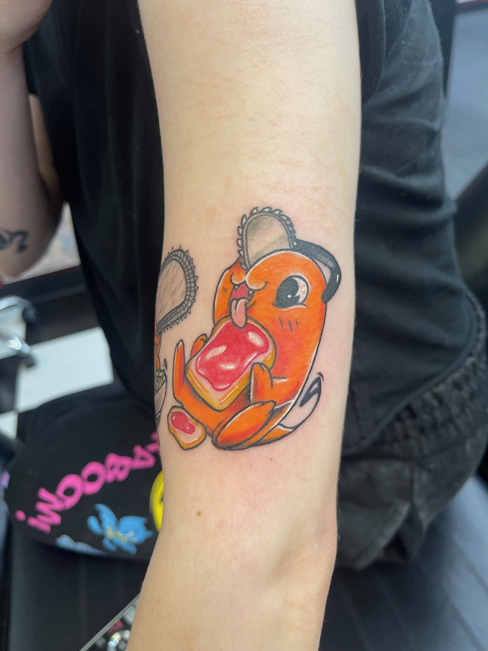 A vibrant cartoon-style tattoo of Chainsaw Man’s beloved companion, Pochita. The bold outlines and bright orange tones perfectly capture this character’s playful yet gritty personality.