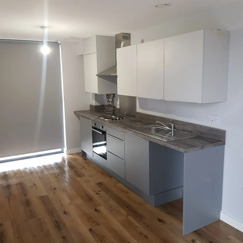 Completed kitchen installation as part of a void refurbishment programme, including new base and wall units, laminate worktop, appliance installation and flooring, delivered to Local Authority housing standards.
