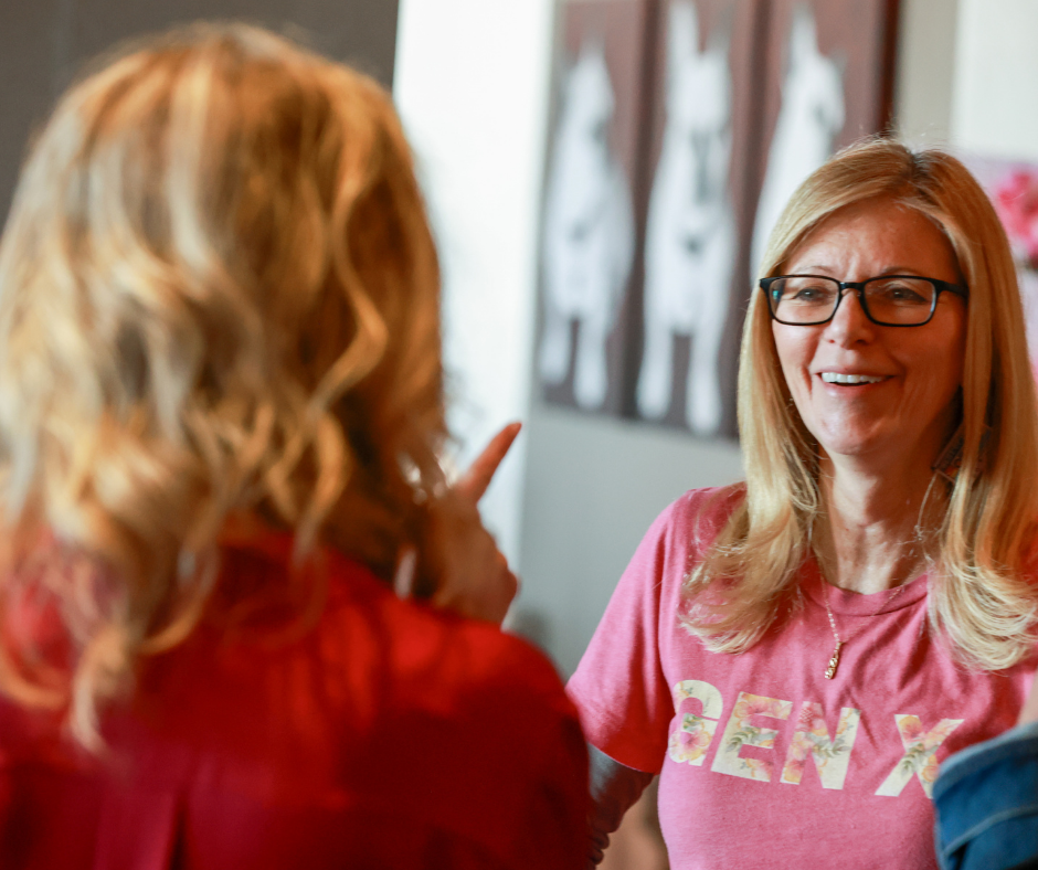 Woman with glasses indoors smiling in a modern workspace, representing Gen X and midlife career confidence through Second Act Women