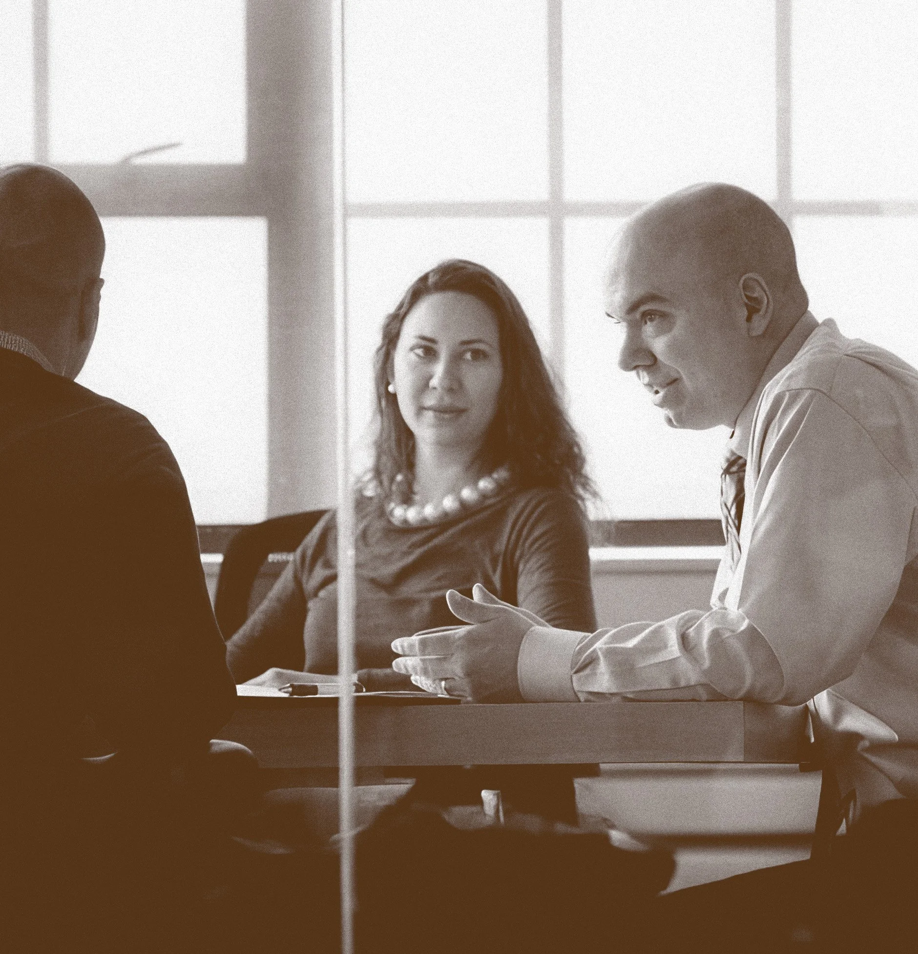 A photo of Shawn in a business meeting with clients.