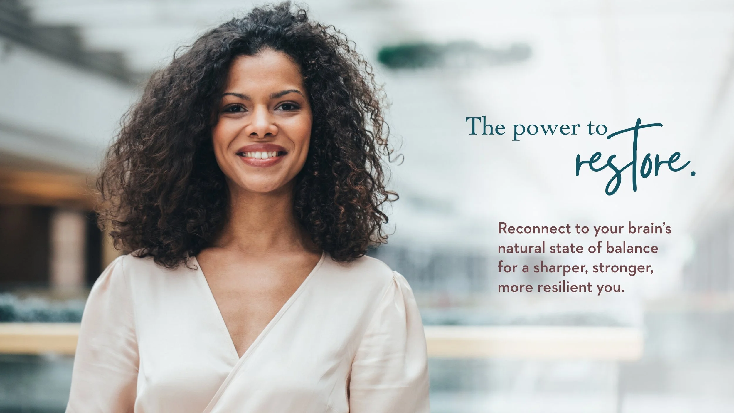 A smiling woman stands in a bright, modern space beside text that reads: “The power to restore. Reconnect to your brain’s natural state of balance for a sharper, stronger, more resilient you.”