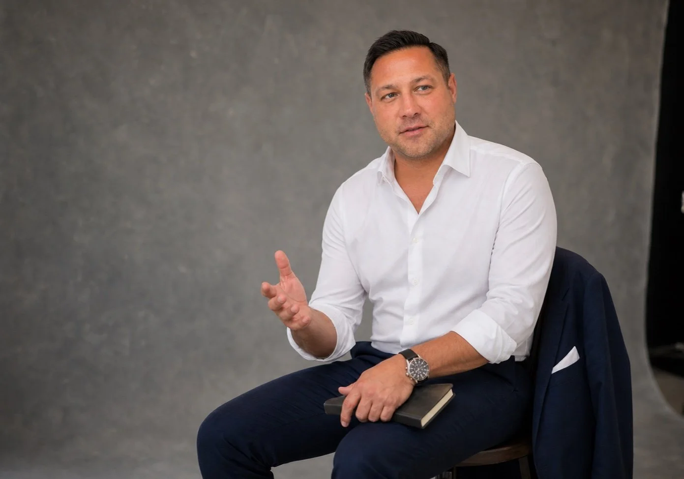 Del Denney seated with a notebook during a professional coaching studio session.