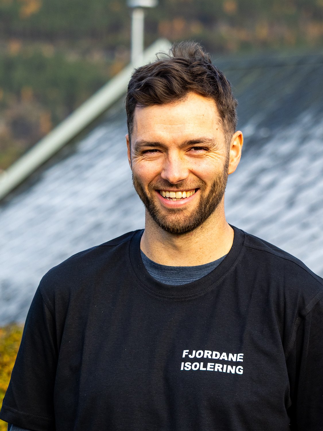 Ein smilande Kjetil Klakegg, som snart skal ta over Fjordane Isolering iført svart t-skjorte med teksten 'FJORDANE ISOLERING'.