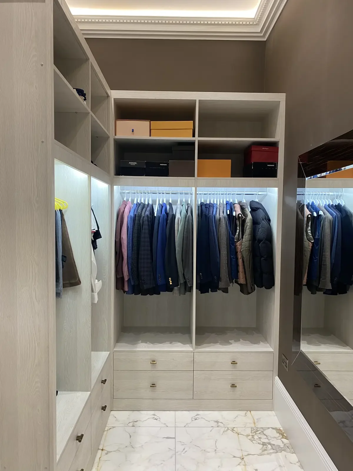 Fitted wardrobe with LED strip lighting and ceiling spots, enhancing visibility and showcasing tailored cabinetry and precise electrical detailing.