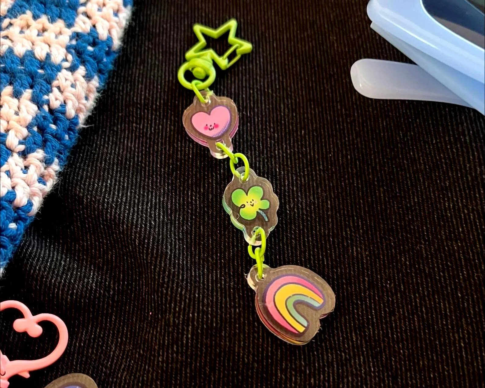 Lucky Charms keychain illustrated gift. Pink and green four leaf clover, hearts and rainbows on a green star shaped keychain.