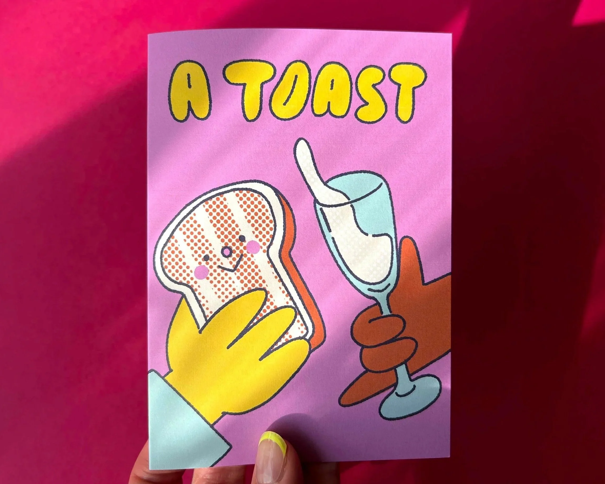 Colourful illustration on a greetings card of a toasted bread slice with a smiling face, and a hand holding a glass of champagne. The text 'A TOAST' is written at the top.