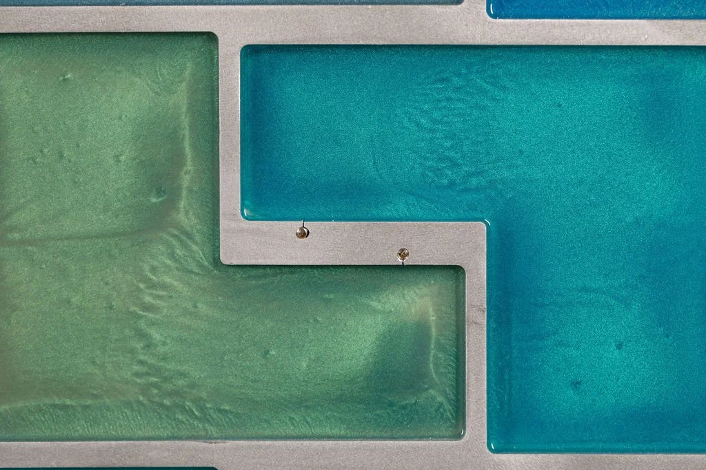 Blue and green resin detail with geometric aluminum framing in modern abstract wall art