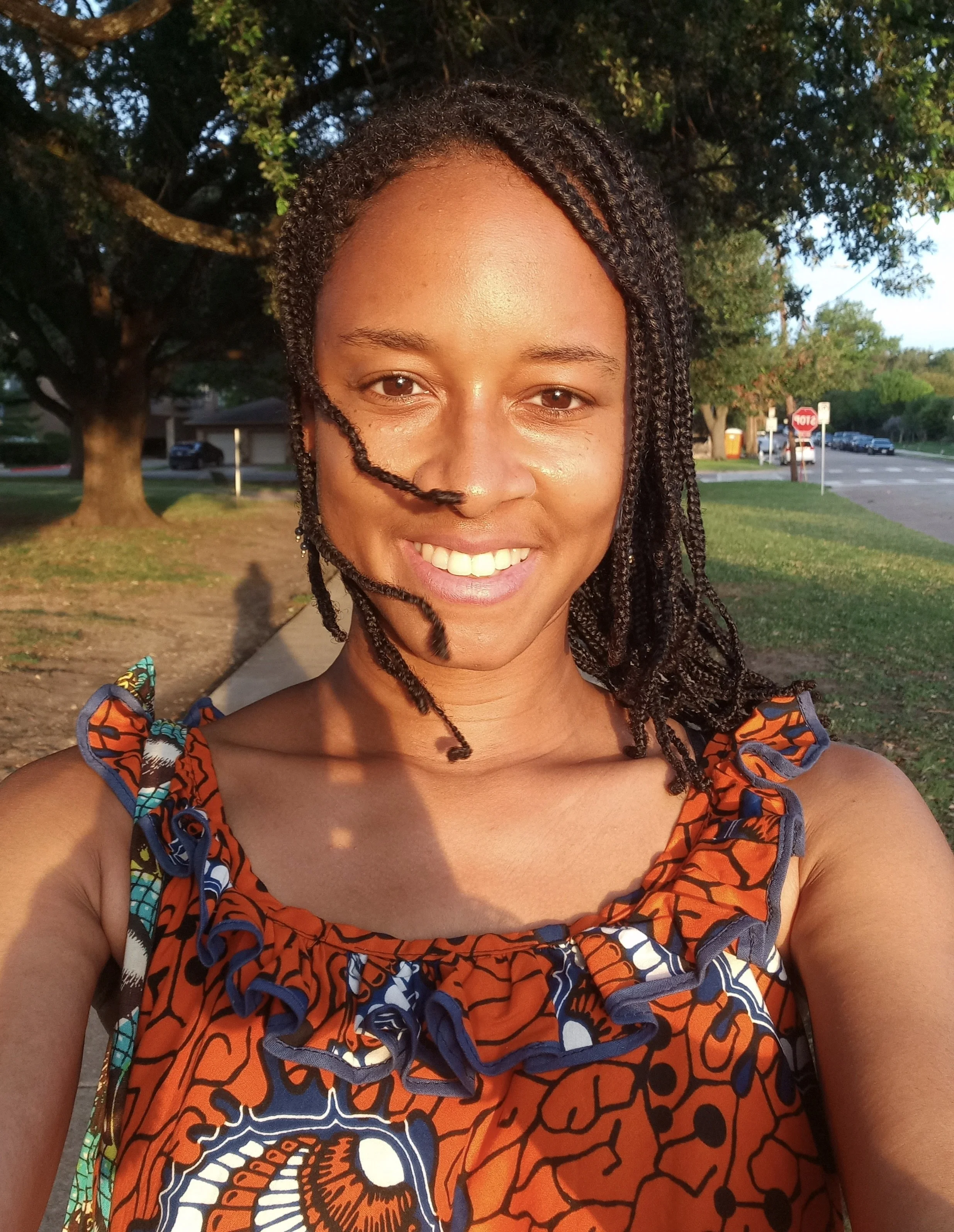 A smiling black woman with hair blowing gently
