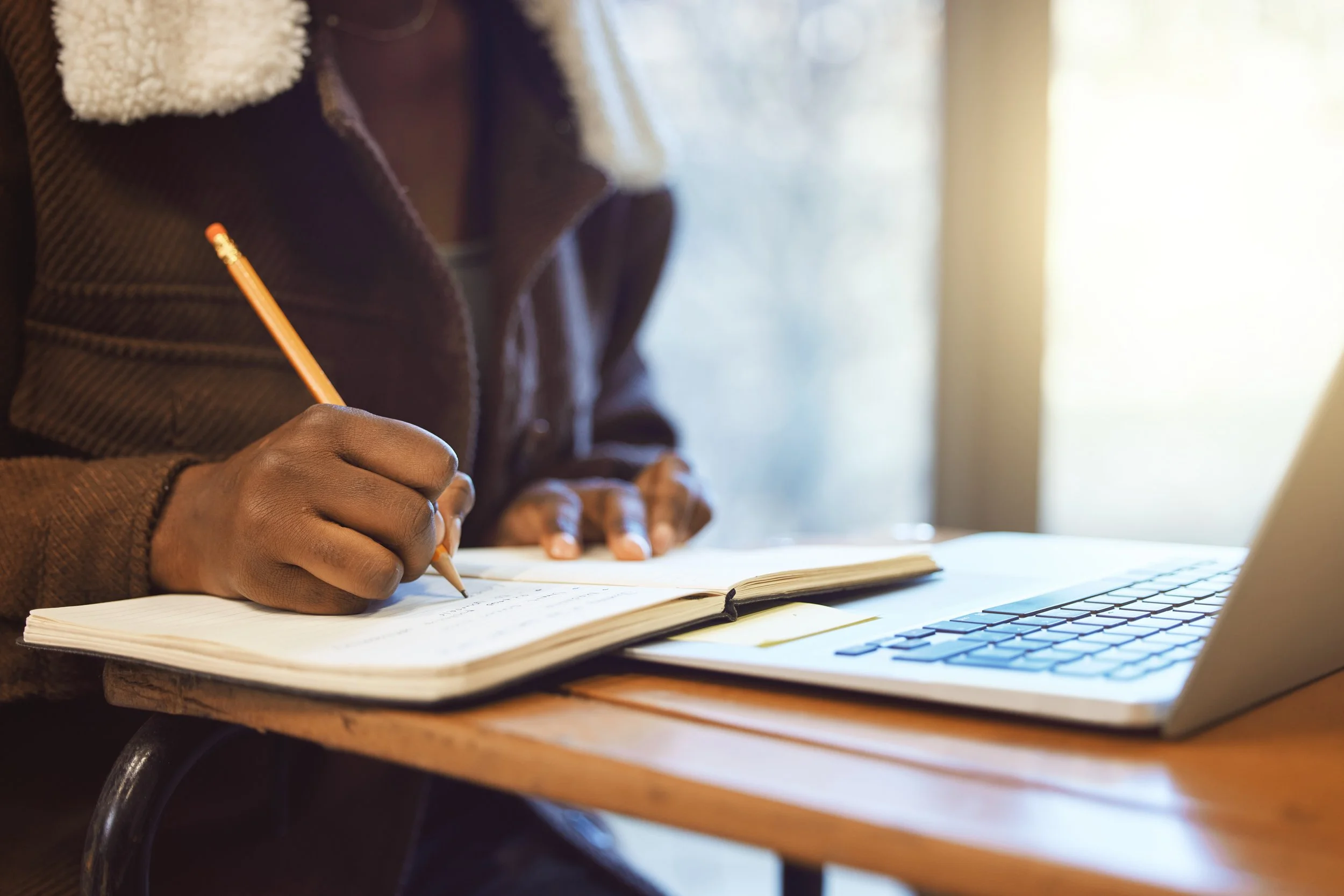 person-writes-in-notebook-with-laptop-computer-2026-03-25-02-46-51-utc.jpg