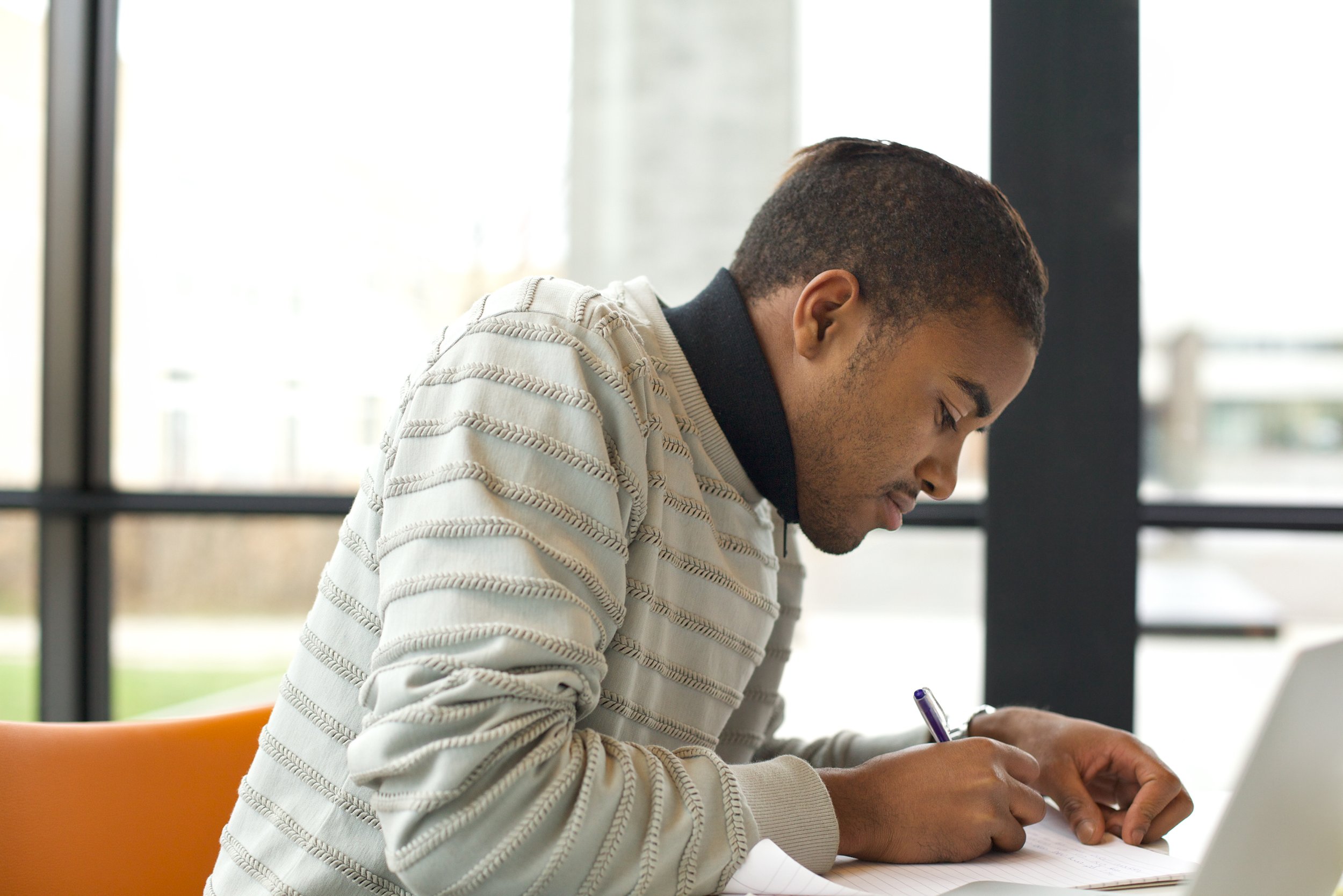 young-man-writing-on-paper-at-desk-2026-01-05-01-11-28-utc.jpg