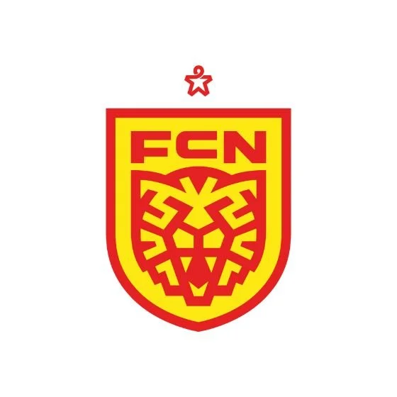 FCN logo with a stylized lion's face in red and yellow, topped with a small red star
