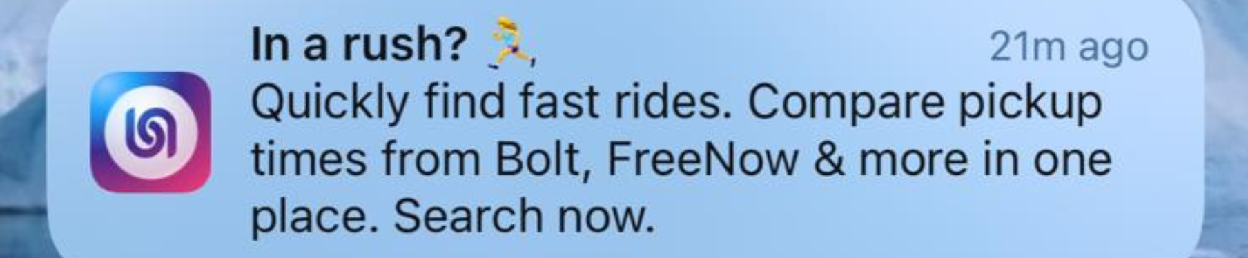Notification on a smartphone screen promoting ride-hailing apps, with an icon of a purple and pink swirl, and text about finding fast rides and comparing pickup times.
