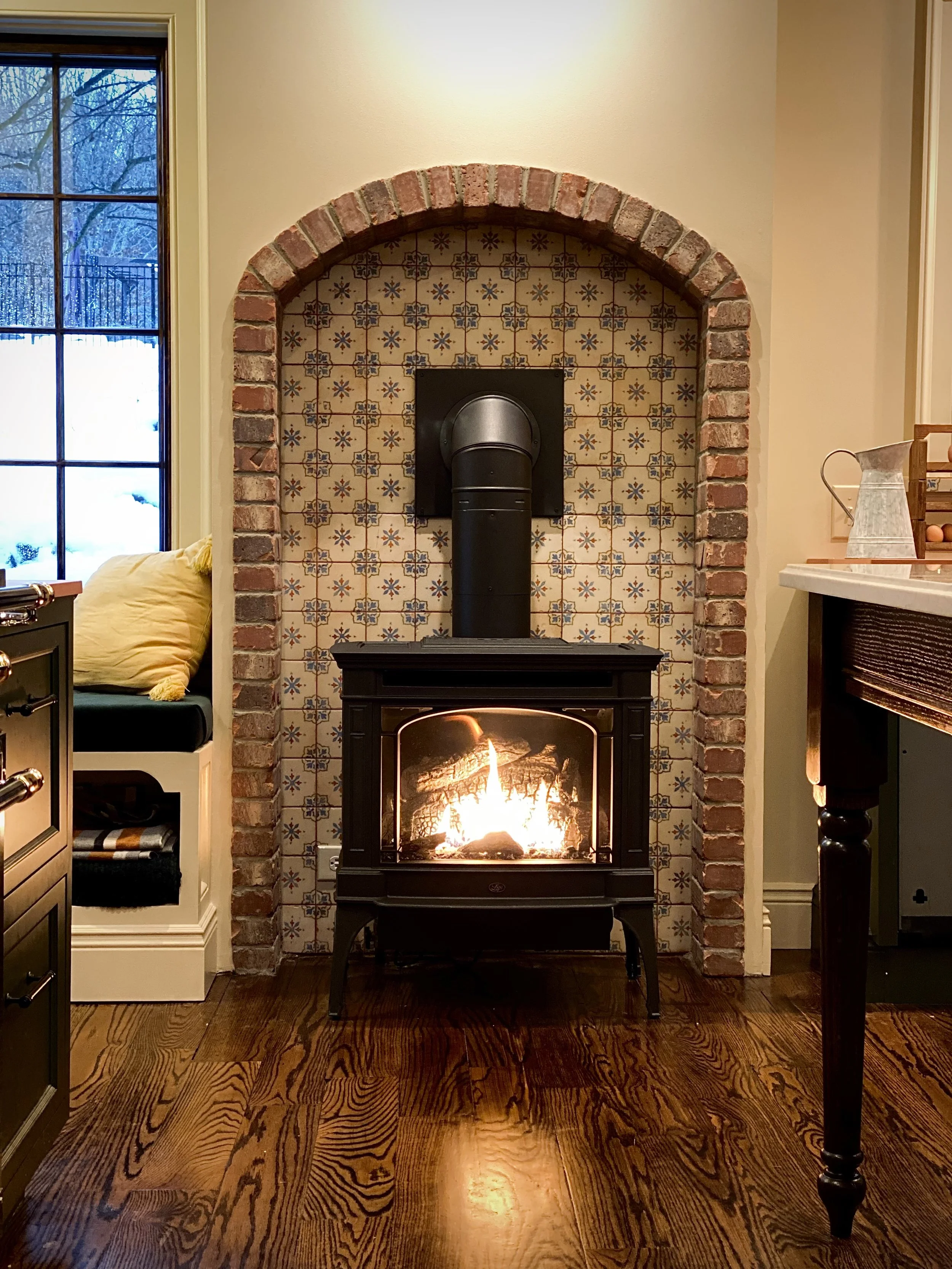 Cozy vintage woodstove with brick and tile surround. designed by Marie Beatrice Interior