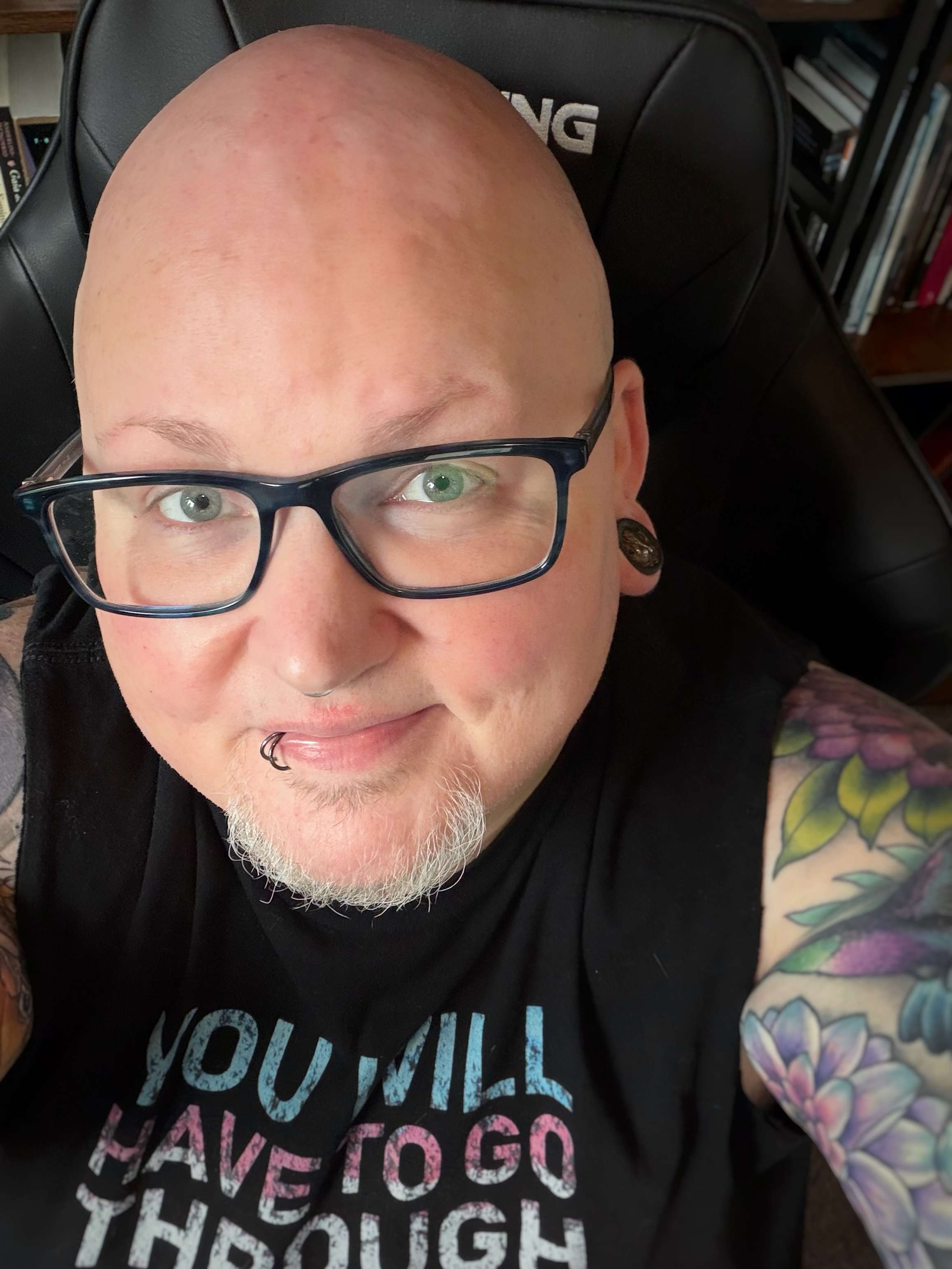 A person with a shaved head, glasses, and a goatee.