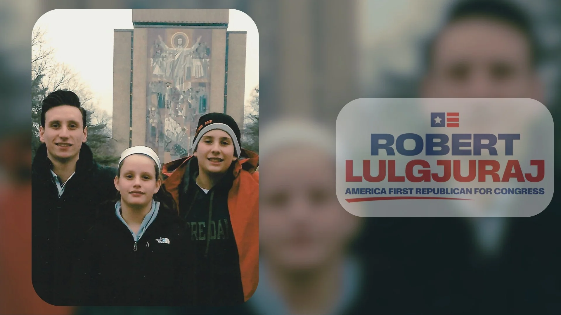 A group of three people standing outdoors in front of a large religious mosaic mural, possibly in a park, with a political campaign sticker on the right side of the image. The sticker displays a political candidate's name, Robert Lulgjuraj, and his c