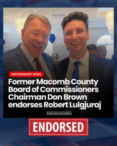 Two men, in suits, smiling at the camera during an endorsement event, with a red banner that reads 'ENDORSED' and text indicating former Macomb County Board of Commissioners Chairman Don Brown endorses Robert Lulgjuarji.