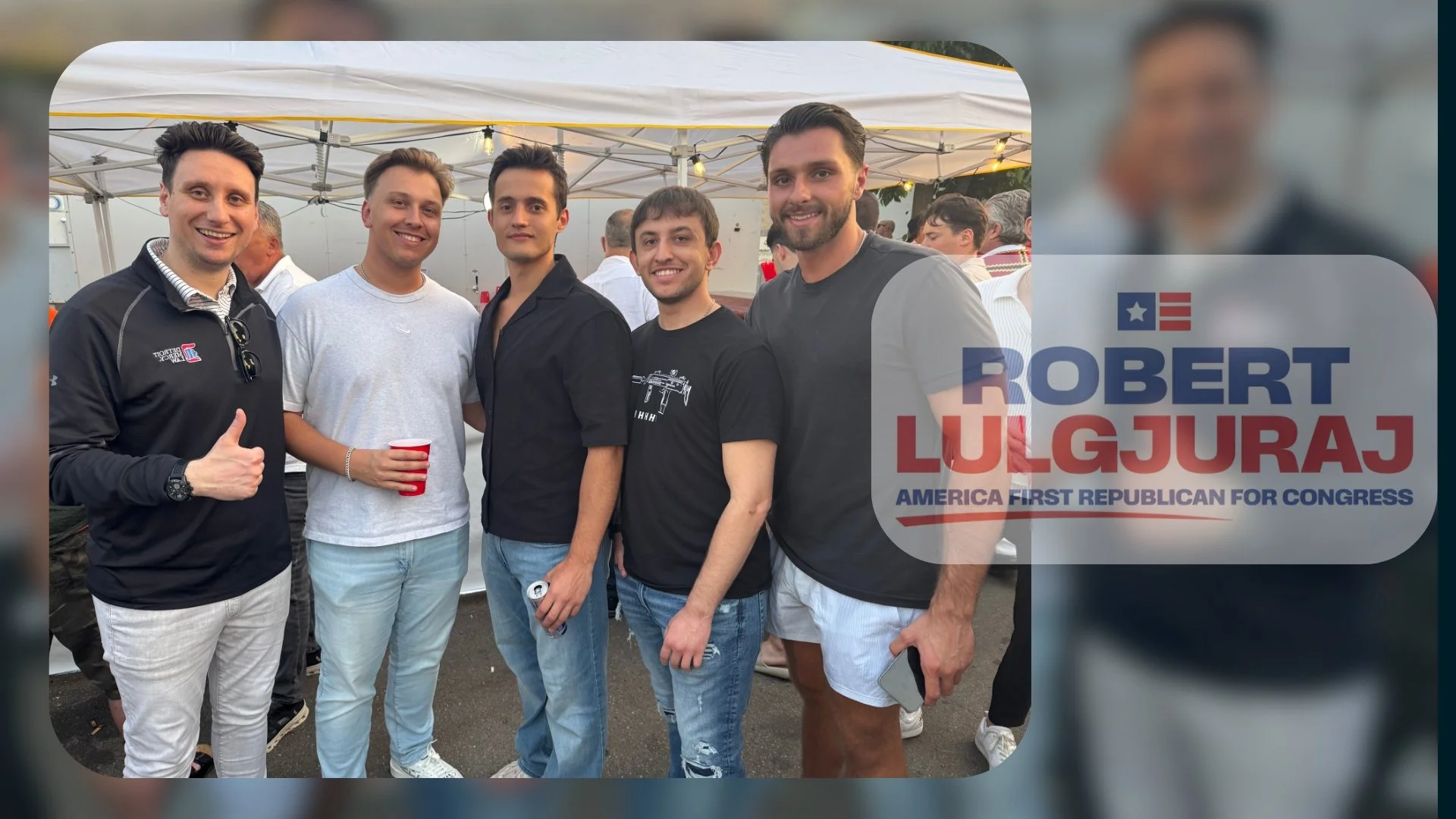 A group of five men standing outdoors at a political event, smiling at the camera. There is a tent and other people in the background. One man on the left is giving a thumbs up and wearing a black jacket. The second man from the left is holding a red