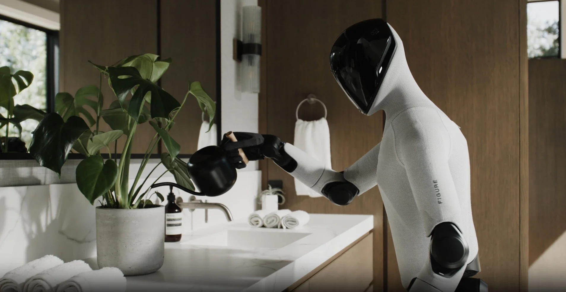 Figure 3, Figureai, humanoid Robot with a human-like body and helmet cleaning a potted plant with a small watering can in a bathroom with natural light, rolled towels, soap, and a towel on a rack.