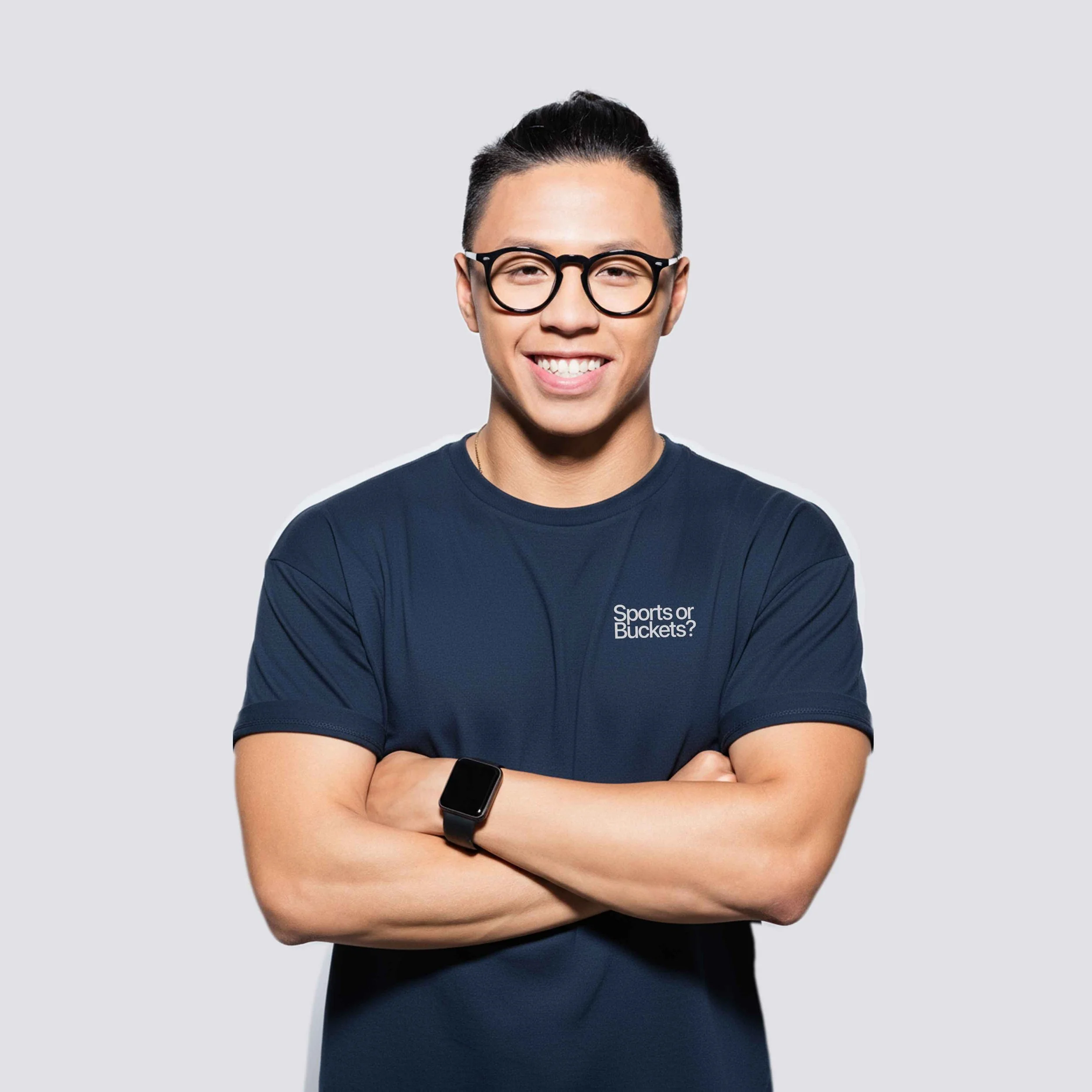 A Porsche enthusiast with black hair, glasses, and a smartwatch, smiling with arms crossed, wearing a navy blue athletic shirt with the text 'Sports or Buckets?' on it.